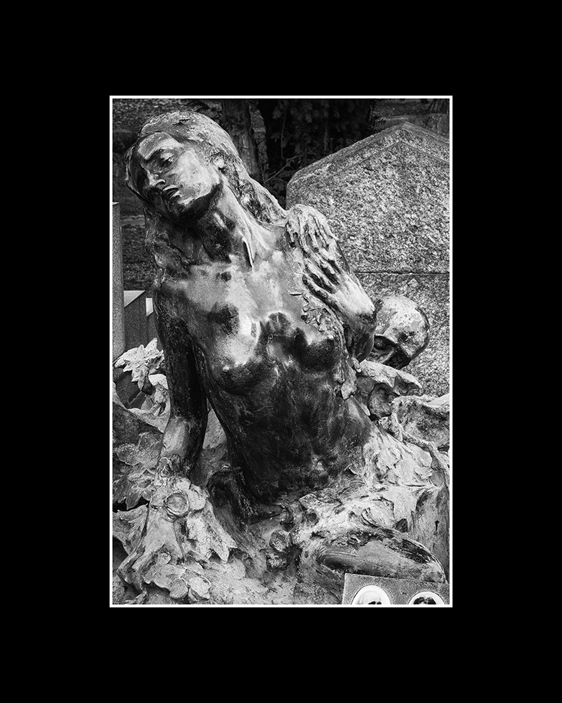 A young woman, bare-chested, sits before a tombstone and struggles desperately against Death, who seizes her from behind.