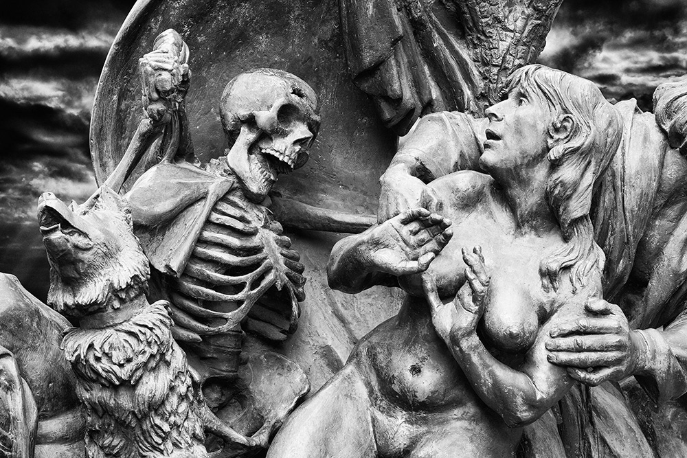 Adam and the naked Eve are driven out of paradise by a sinister skeleton man with a whip. A wolf howls eerily.