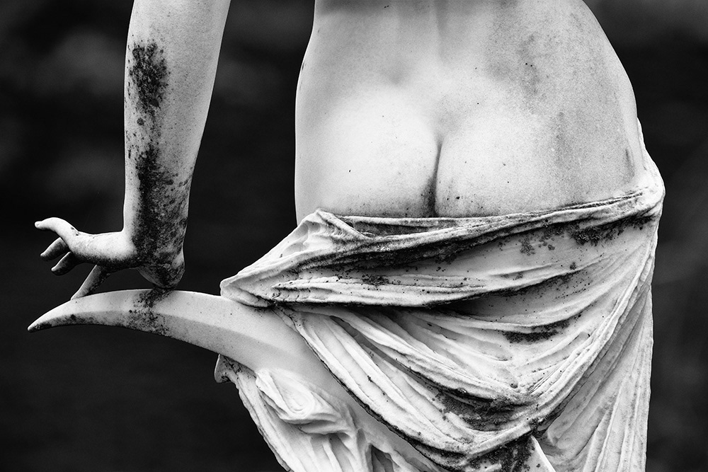 Sculpture on so-called “angel lawn”. The detail shows the naked buttocks of a young woman sitting on a crescent moon.