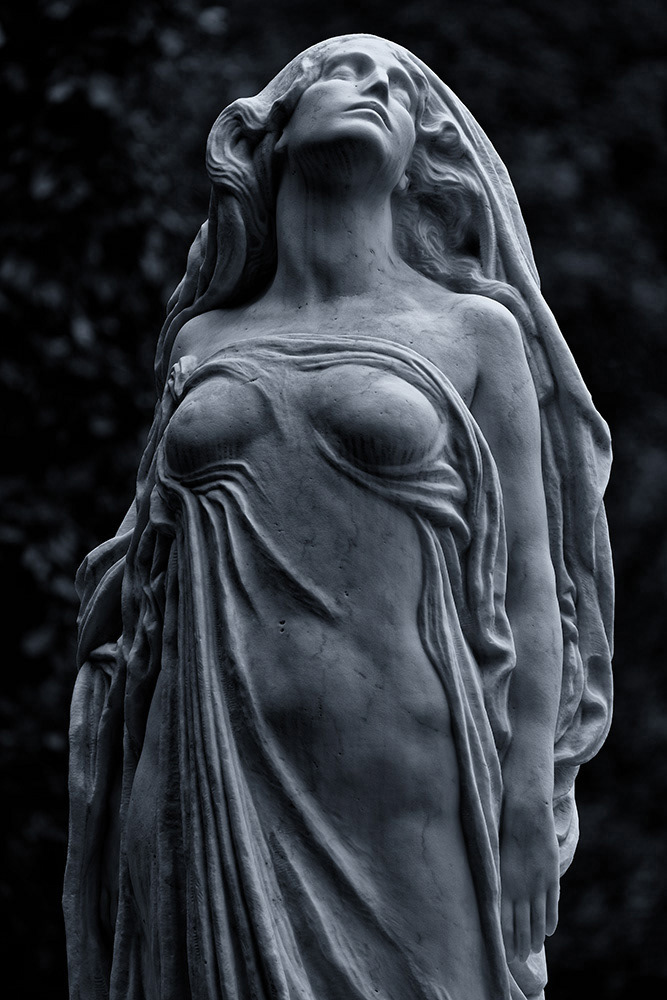 An elegiacally dressed woman dreams of heaven. Her body glows with light that emanates from without a direct light source.