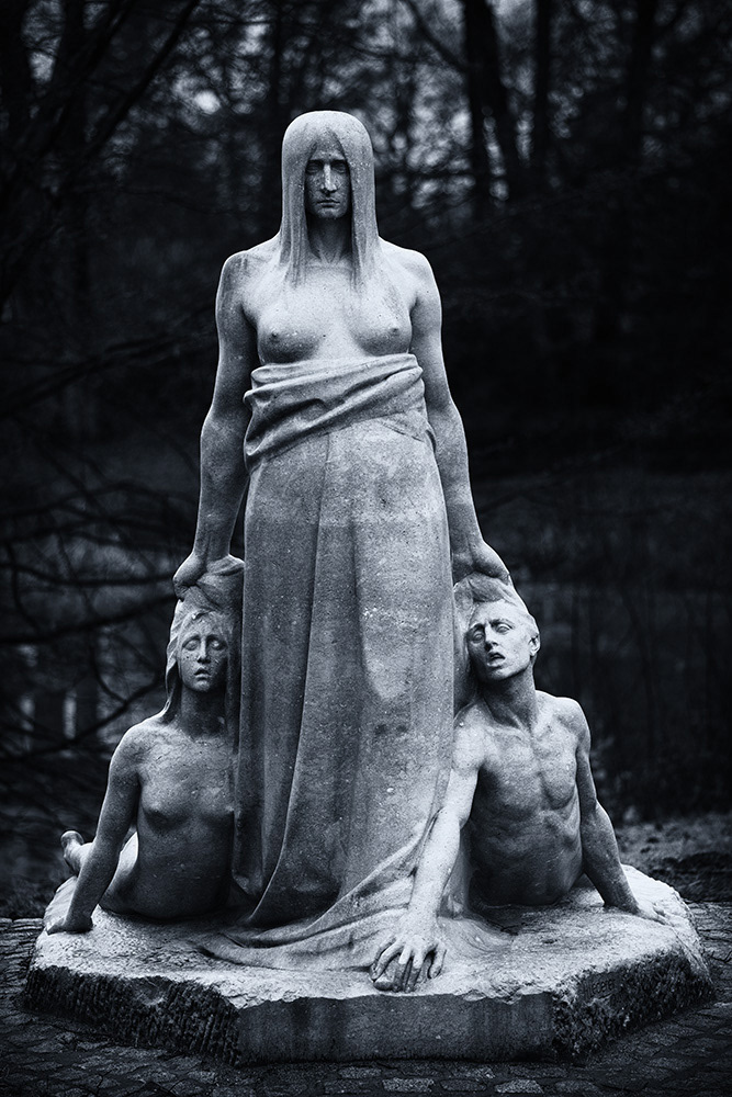 The bare-breasted fate strides darkly and inexorably onward, its hands grabbing a boy and a girl by the hair.