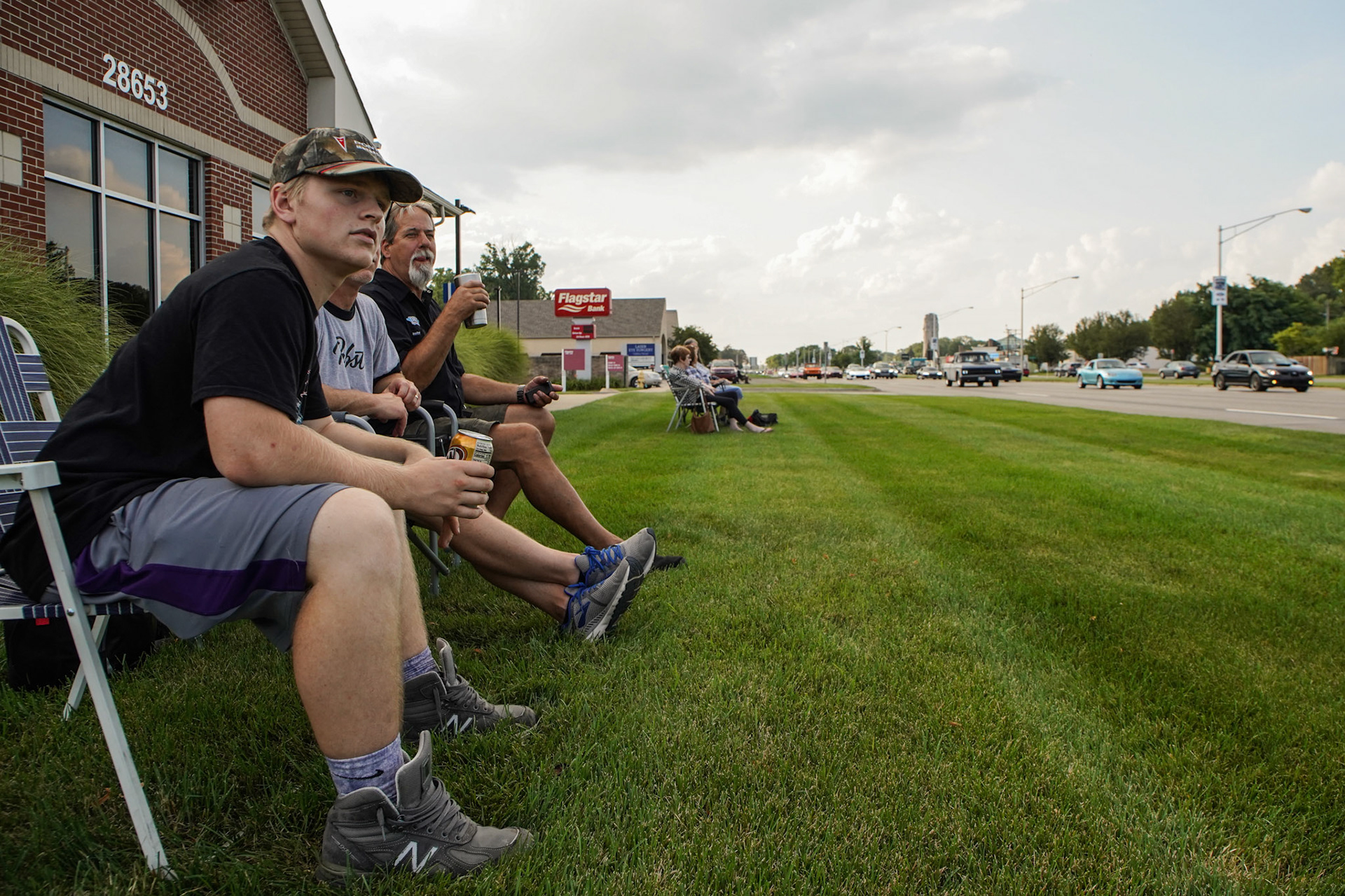 Anthony Castrigano, 19, Chad Castrigano, 47, and Steve Vachon, 59, of Brunswick, Ohio talk and watch classic cars drive down Woodward Avenue in Royal Oak on Thursday, August 19, 2021. The Woodward Dream Cruise, the world's largest one-day car event is returning after taking a break due to COVID-19.