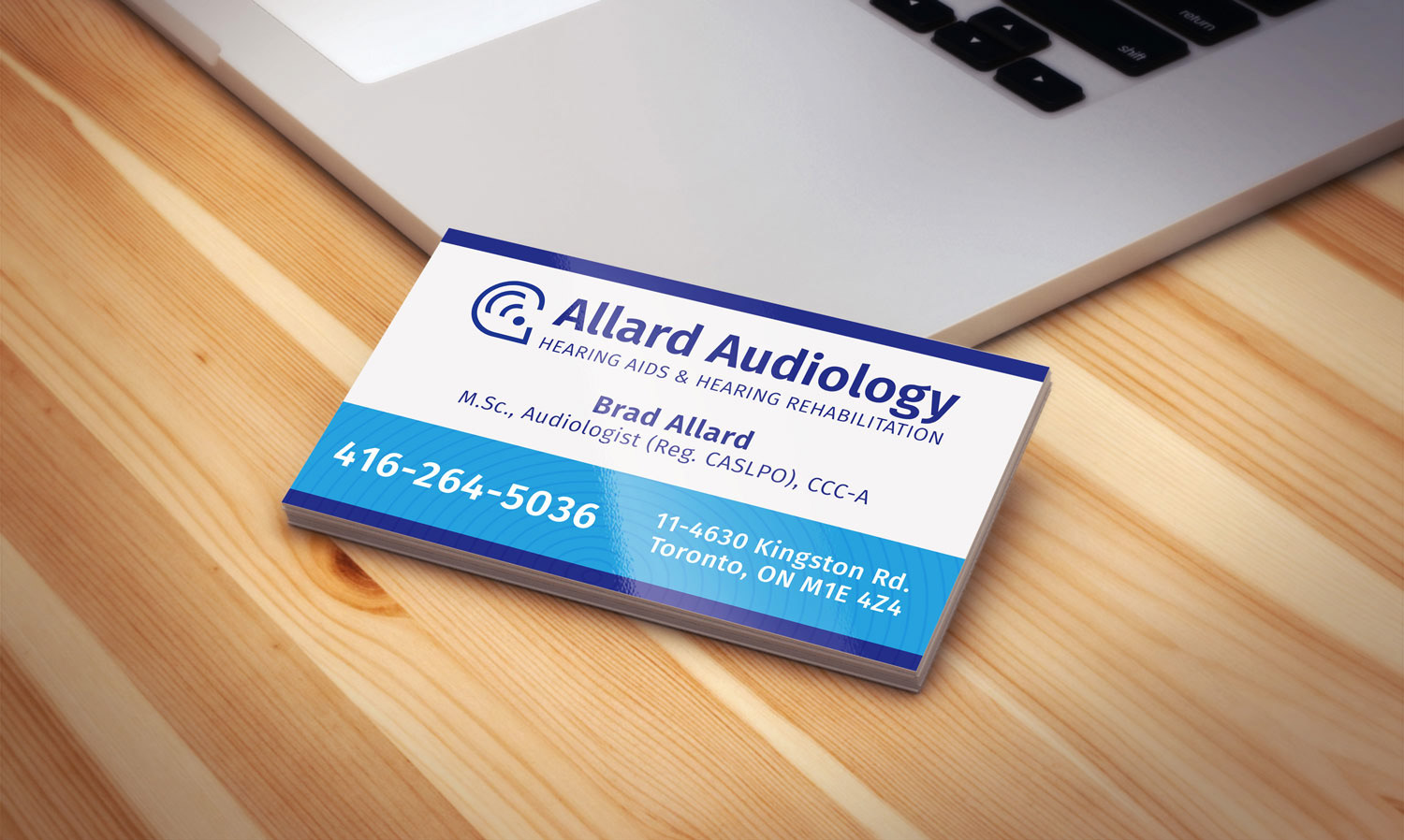 Business card mockup for Allard Audiology. Card design uses deep blue bans to frame the card while a blue accent divides the contact information.