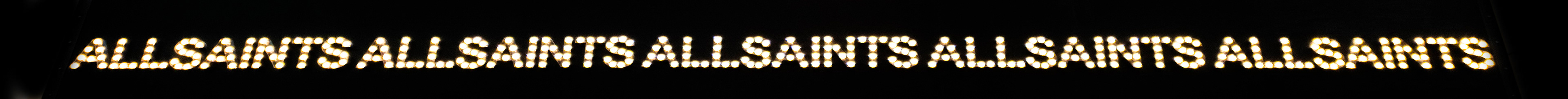 Bright, dotted letters spelling "ALL SAINTS" are repeated in a row against a dark background, creating a modern and bold visual effect.