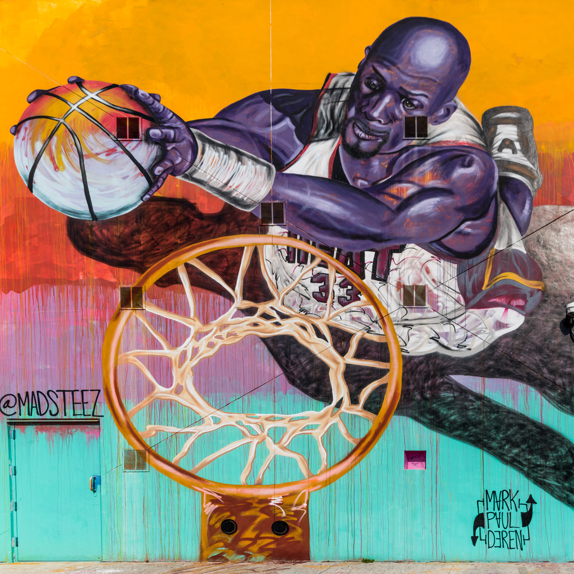 A vibrant mural featuring a basketball player dunking with dynamic movement. The player has purple skin tones, set against a colorful background.