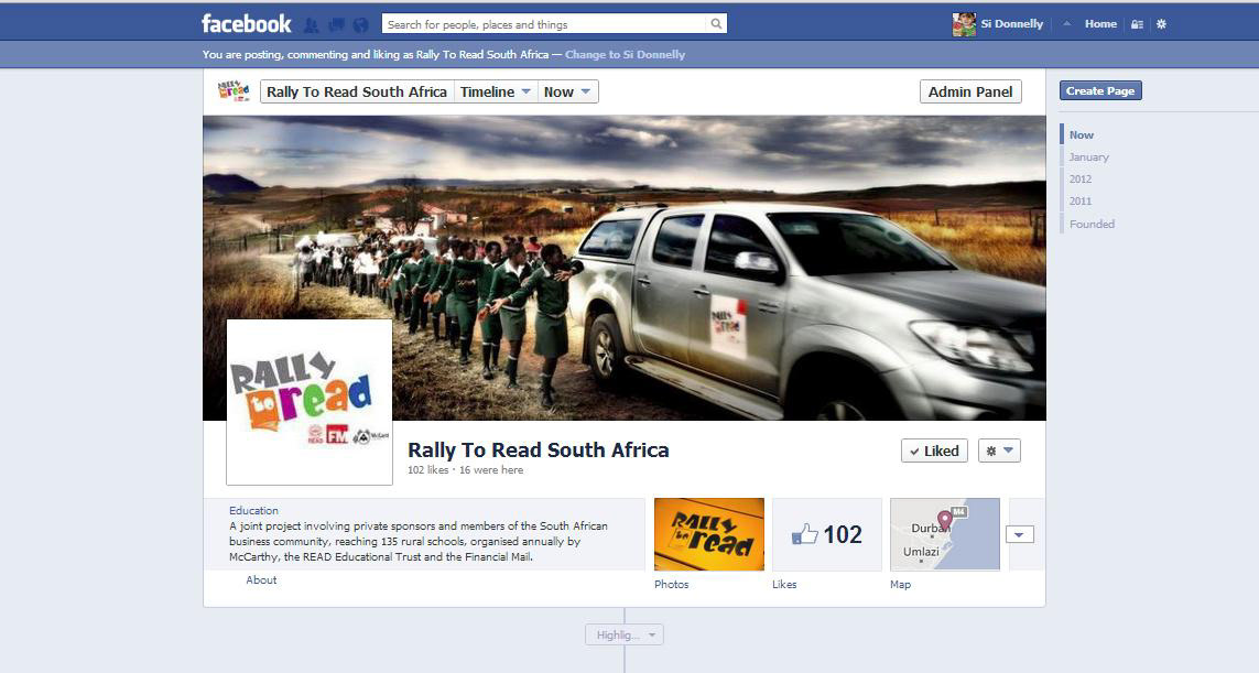 A procession of schoolchildren in uniform walk through rural South Africa beside a silver SUV. The scene is on a Facebook page for "Rally To Read South Africa