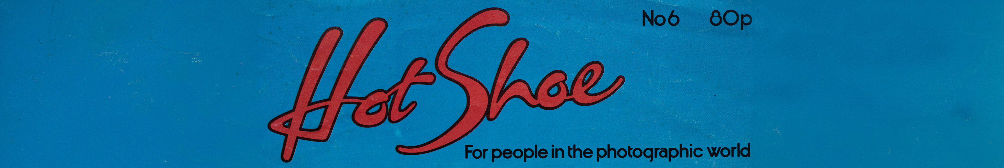 Bright blue background with "Hot Shoe" in bold red cursive. Caption: "For people in the photographic world," conveys a creative and welcoming tone.