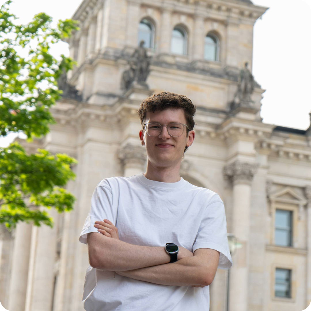 Vincent Ludewig steht mit verschränkten Armen vor dem Reichstaggebäude in Berlin.