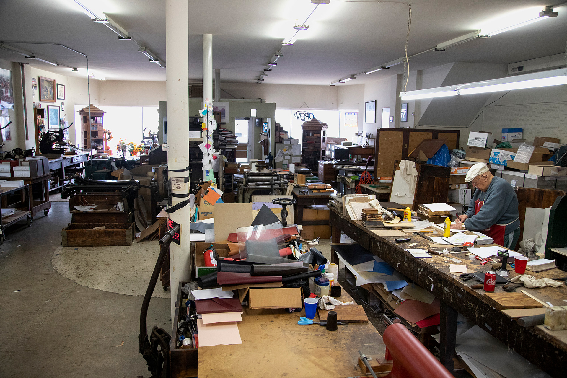 Ron Bowman works at the table where he spends most of his time with decades old books that need a new finish. Ron lives a few blocks away from the shop in Columbus, Ohio, which allows him to get to and from his work easily.