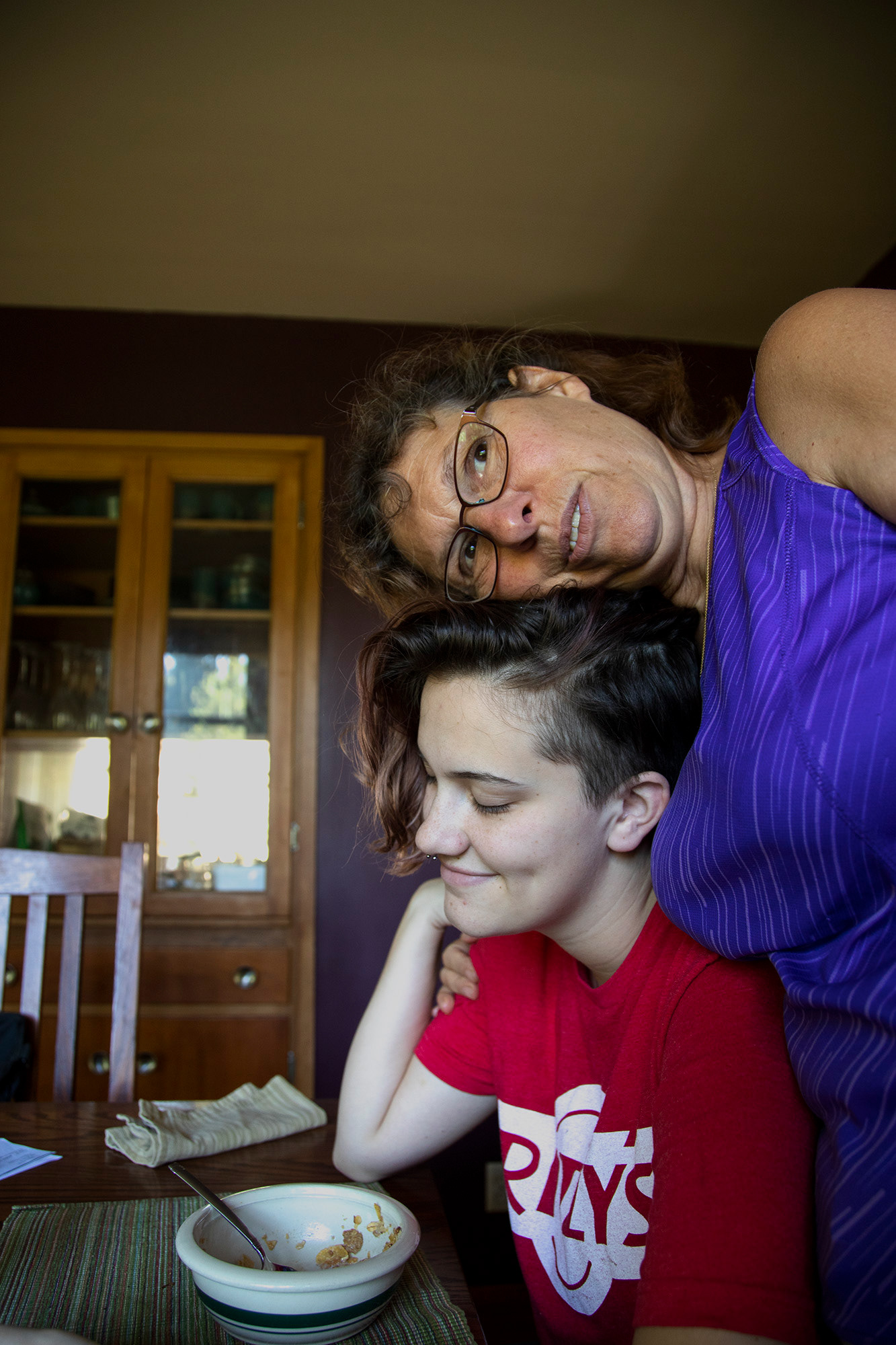 Marie Boozer, top, embraces Orion Hower, lower, as if Hower was Boozer’s own child in an attempt to make them feel better and provide emotional support about going to a job that Hower dislikes.