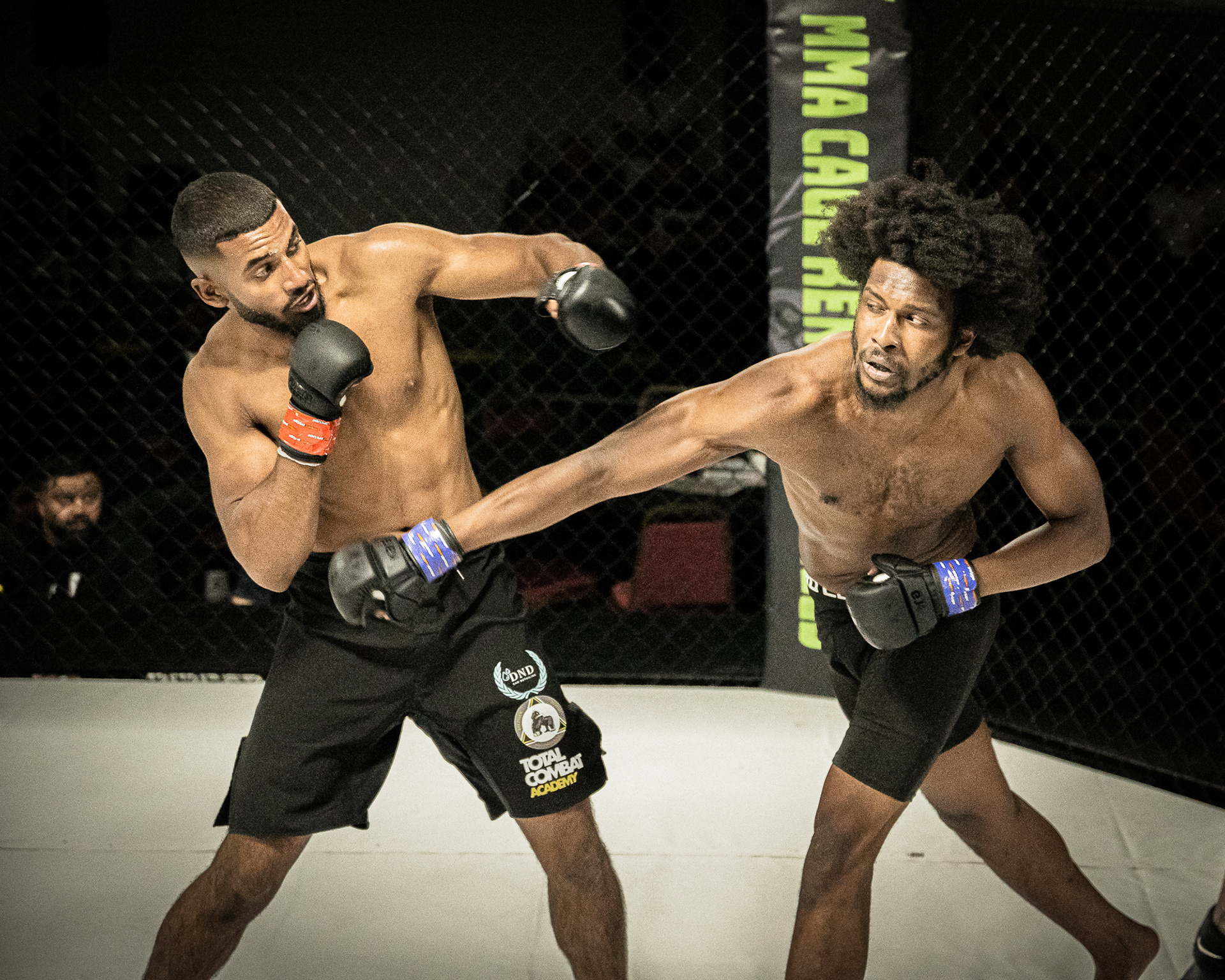 2 MMA Fighters fighting in a ring shot by a photographer