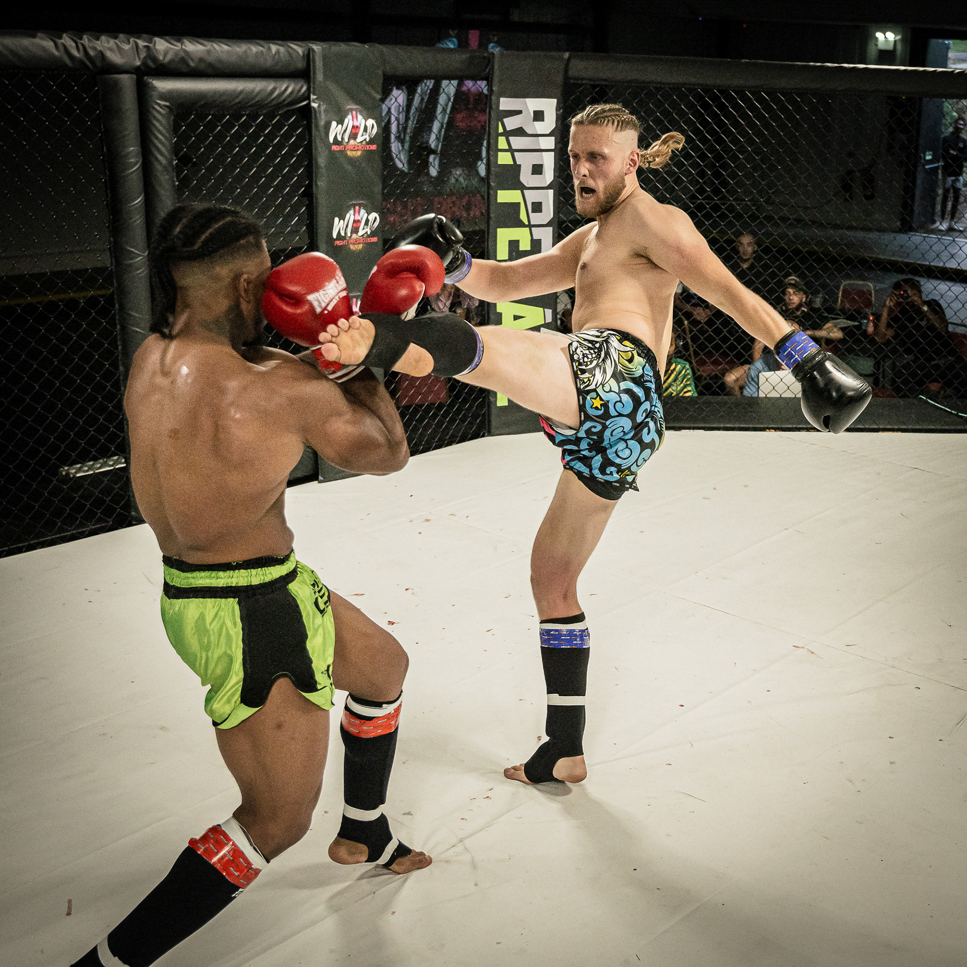 2 MMA Fighters fighting in a ring shot by a photographer