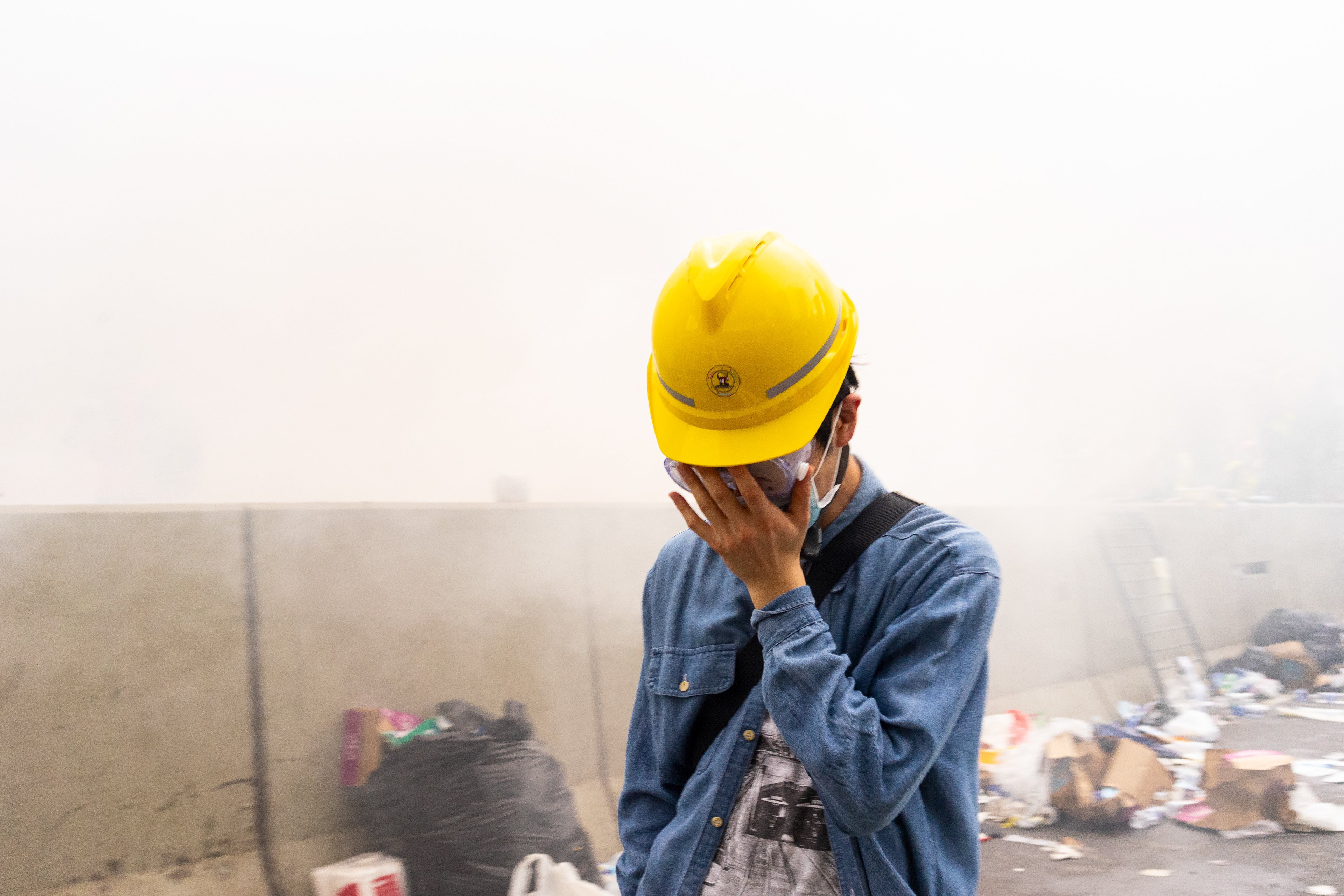 A protester endures the onset of the pain of tear gas. His protections are meager against the gas. Protestors in Hong Kong take to the streets again. This time to fight a new proposed law, that would allow for Hong Kongers arrested in the city to be extradited to China. June 12, 2019 - Hong Kong