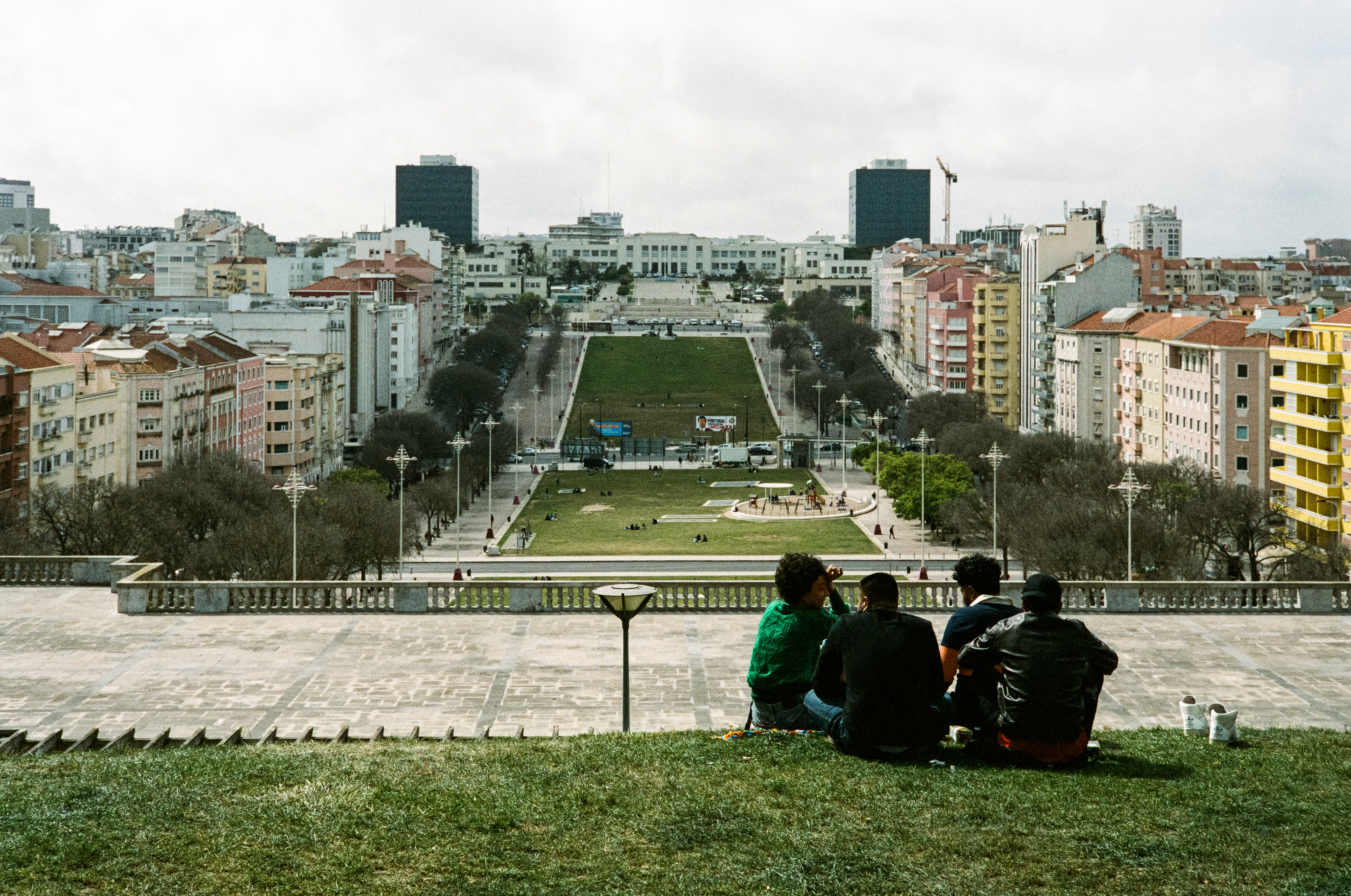On top of the Fonte Luminosa a group of friends smoke pot, share snacks and laugh into the afternoon. In the distance sits the Instituto Superior Tecnico. March 30, 2023-Lisbon, Portugal-Photo by Aaron Guy Leroux
