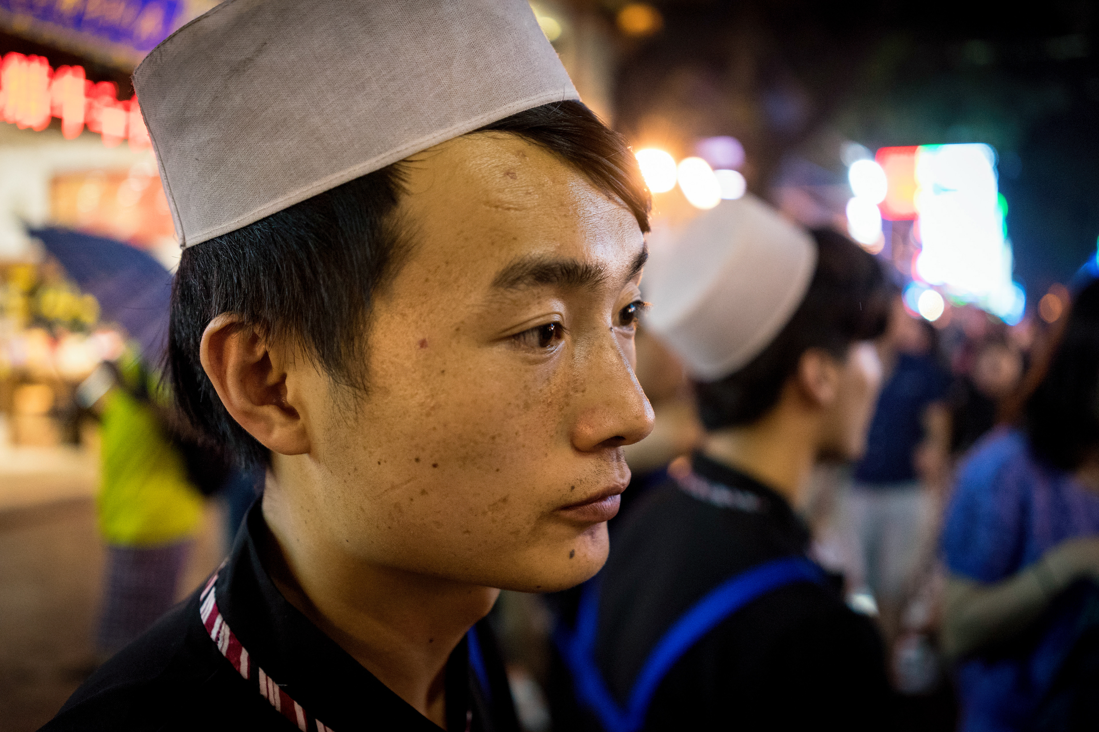 The night market in the Muslim Quarter of Xi'an, China. This Muslim man takes a break from tending the line to his ròujiāmó stand (chinese hamburger). The muslims here have been in Xi'an for thousands of years. This man, and his peers, are direct descendants of the first Muslims to settle here in 651 A.D.