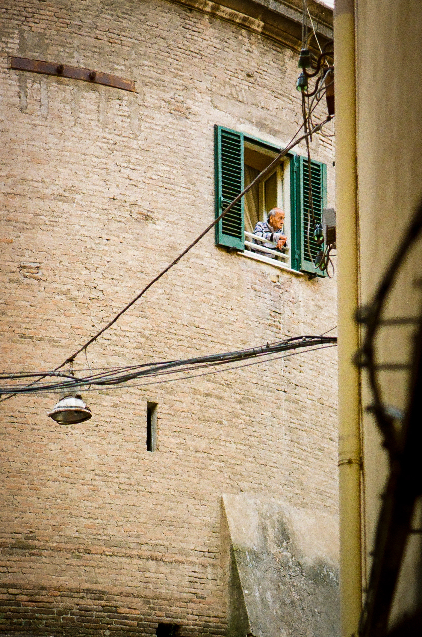 Napoli Afternoon: An elderly man takes in the streets of his neighborhood in Napoli at the end of a long day. June 2022 - Napoli, Italy - Photo by Aaron Guy Leroux