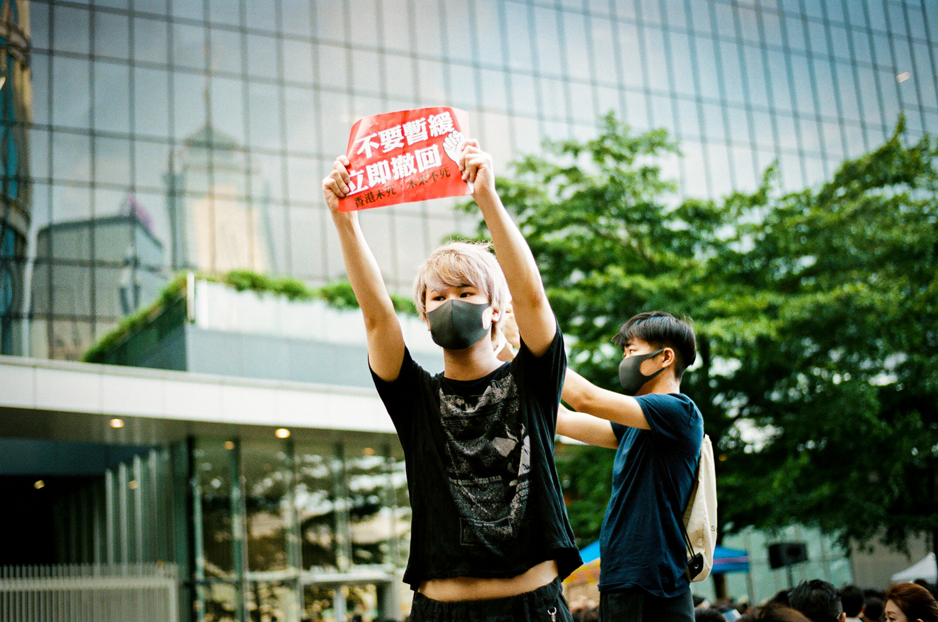 Admiralty, Hong Kong: A masked protestor holds up a sign that translates to "No Suspension, Retreact Immedieately. Hong Kong and its future is not dead yet." Hong Kongers took to the streets on Sunday, to push for the eradication of a proposed extradition bill that would have seen Hong Kongers arrested in the Special Administrative Region extradited to China. The bill was officially “suspended” by the Hong Kong’s Chief Executive Carrie Lam on Saturday. June 16, 2019 - Hong Kong, 35mm