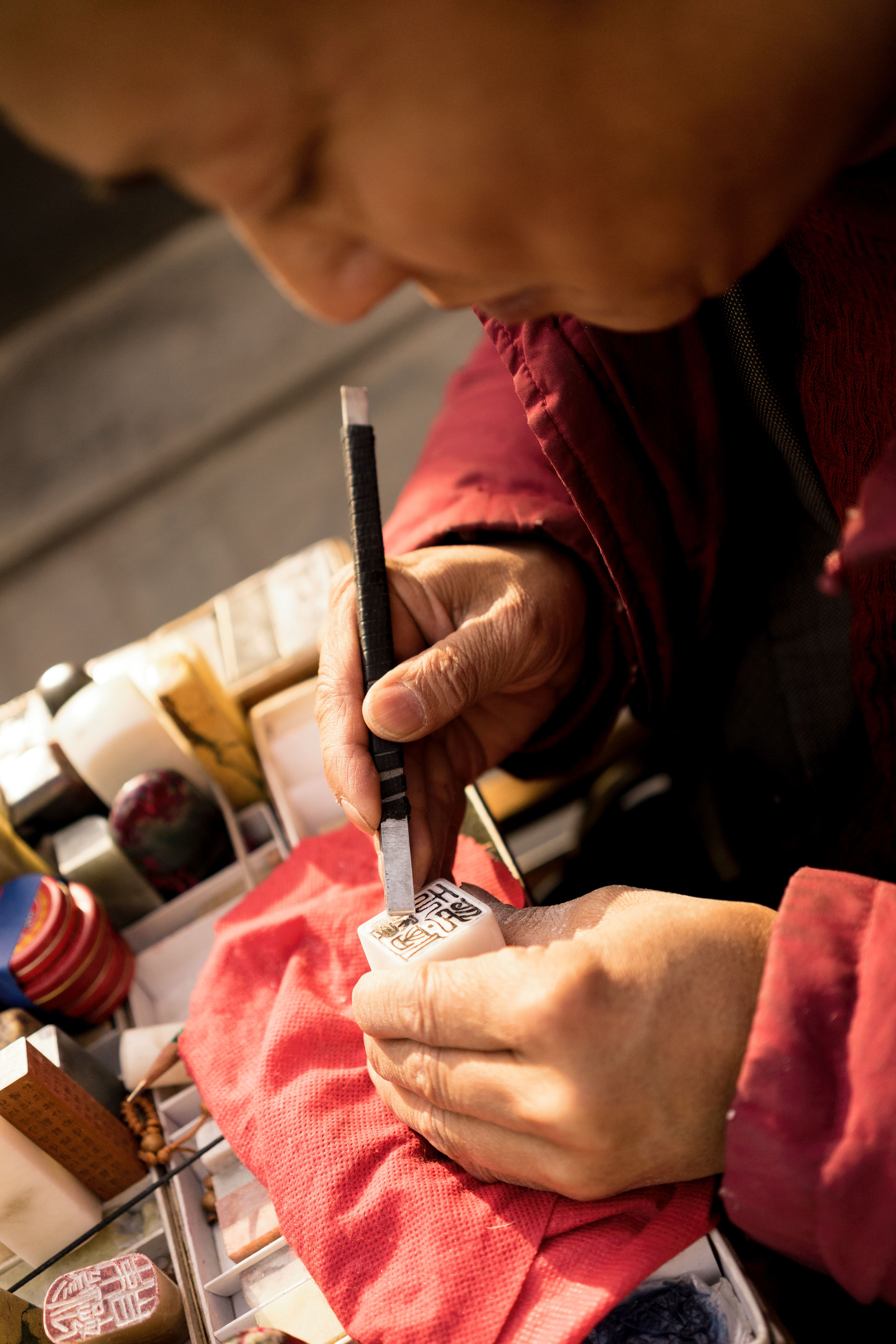 The Stamp Man: Every afternoon he parks his scooter outside the gate to my University. He sets up his little desk and hand carves stamps into soapstone. He has several completed of which you are free to choose. However, he also takes requests. For around 50RMB he will carve your chosen design. 