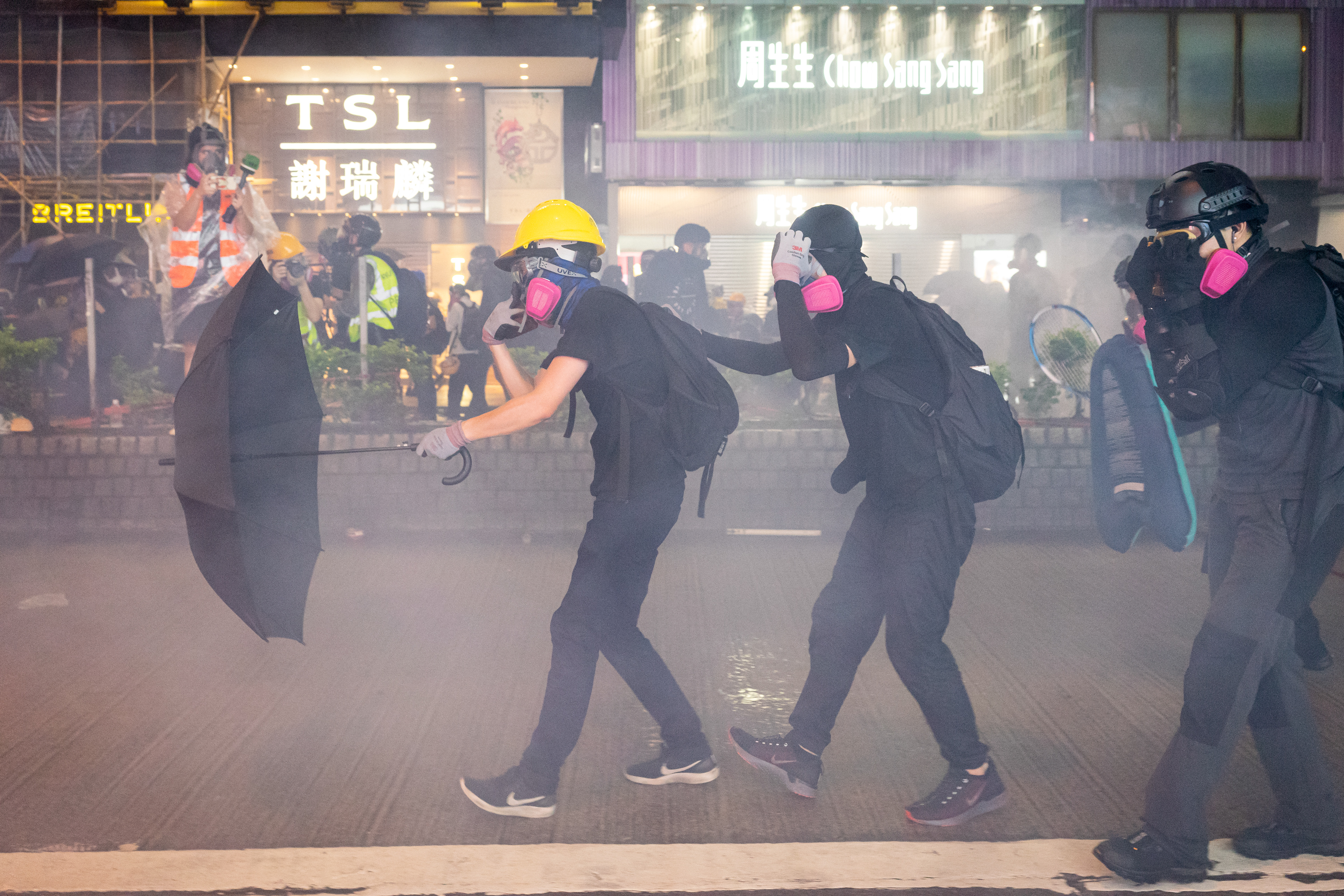 Small Team: Causway Bay, Hong Kong: A small group takes the lead in confronting riot police as tear gas rains down. The August 31st protests marked the 5th anniversary of the Chinese governments refusal of universal suffrage for Hong Kongers. The initial refusal was the impetus for the Umbrella Movement protests in 2014. August 31, 2019-Hong Kong