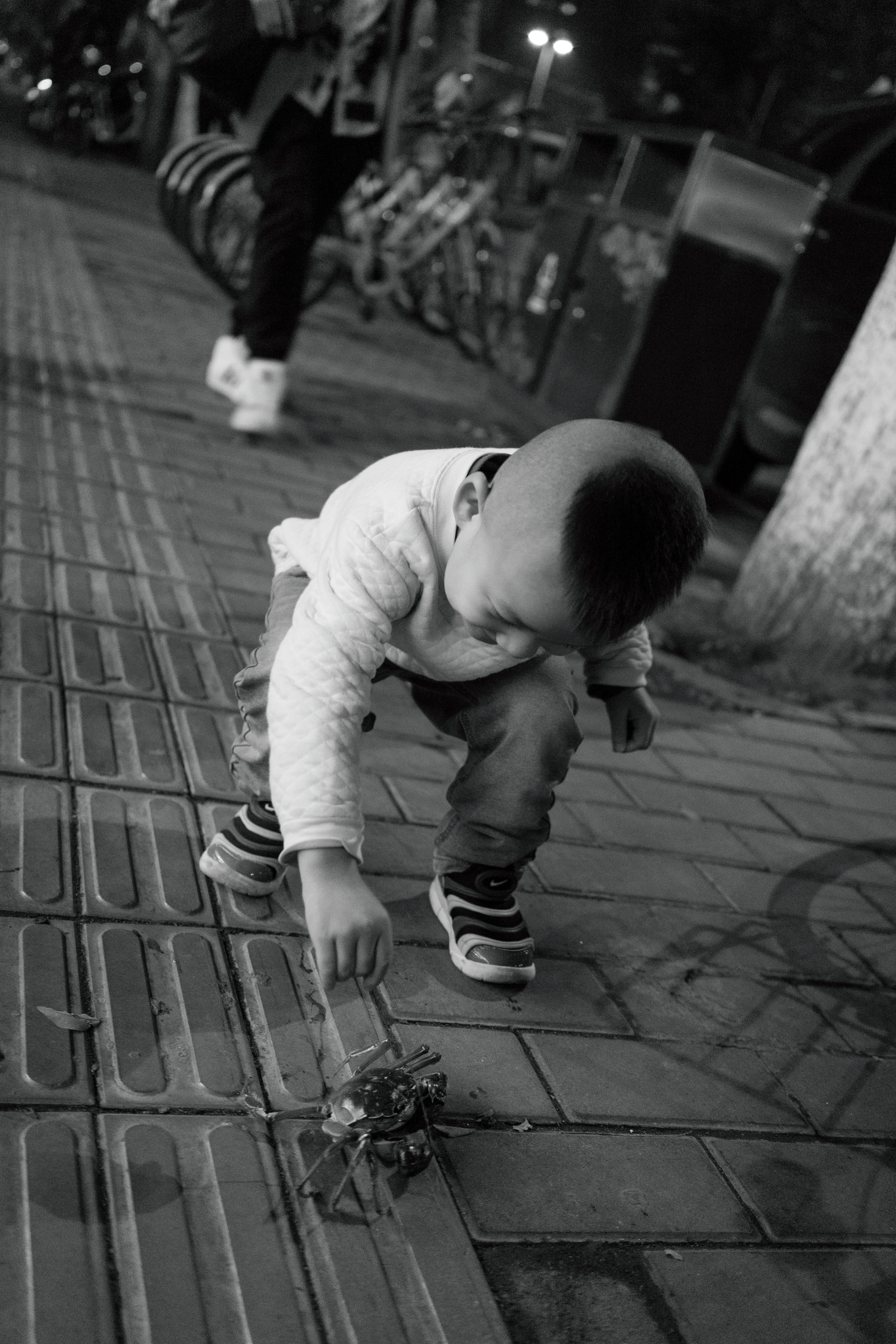 Tormentor: A small boy torments a crab. Yes, there are crabs on the sidewalk here in Xi’an.