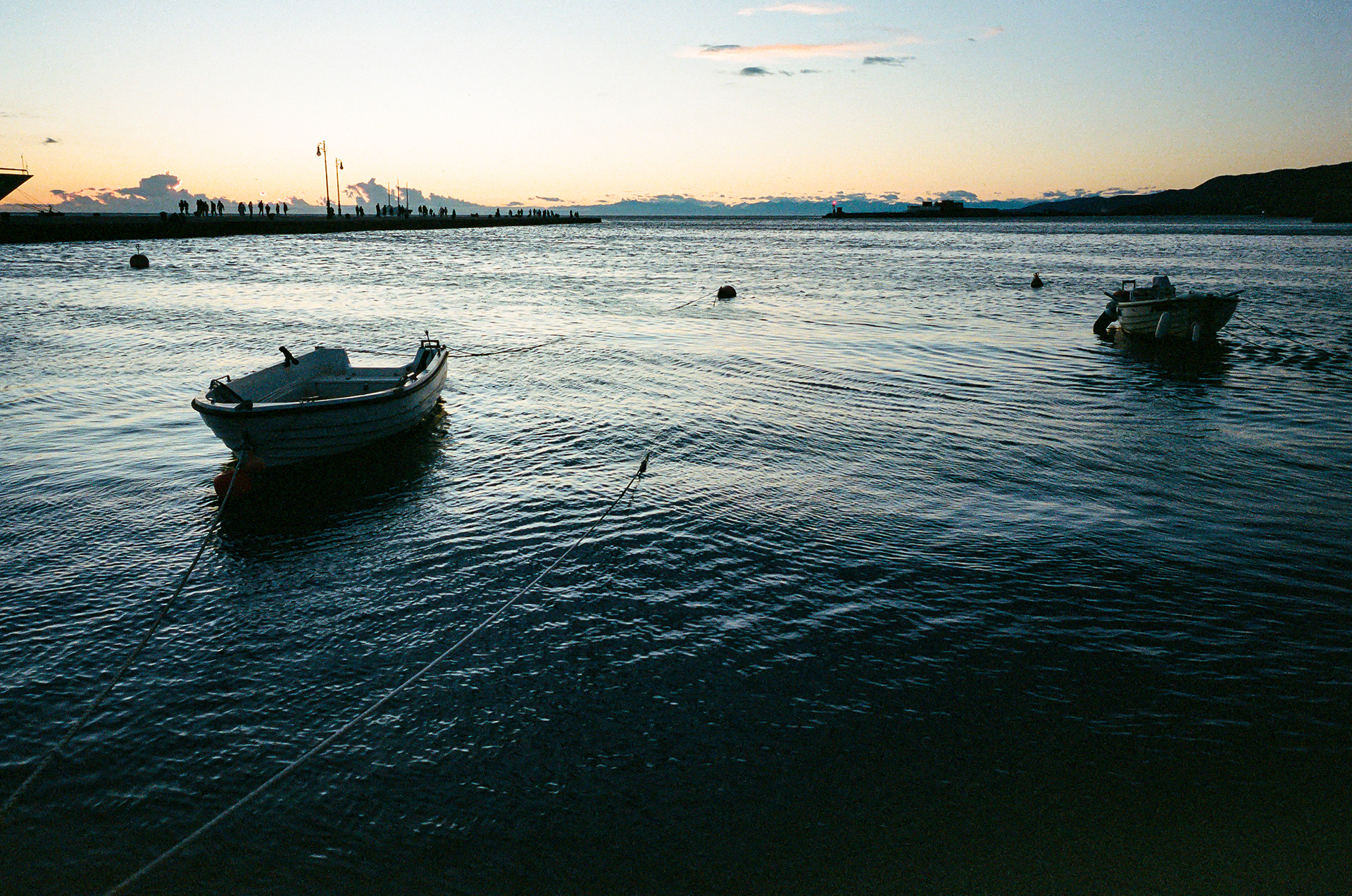 The Waterfront - Trieste bleeds into the Gulf of Trieste. There are few, if any, gates or obstacles of any kind blocking your entrance to the sea and there is certainly nothing stopping the sea from dragging all of Trieste into itself. This closeness gives the city a dreamy quality, particularly when you stand out by the water. There is nothing between you and oblivion but a stone staircase leading into the dark nothingness of the water. Photo by - Aaron Guy Leroux - September, 2024 - Trieste, Italy