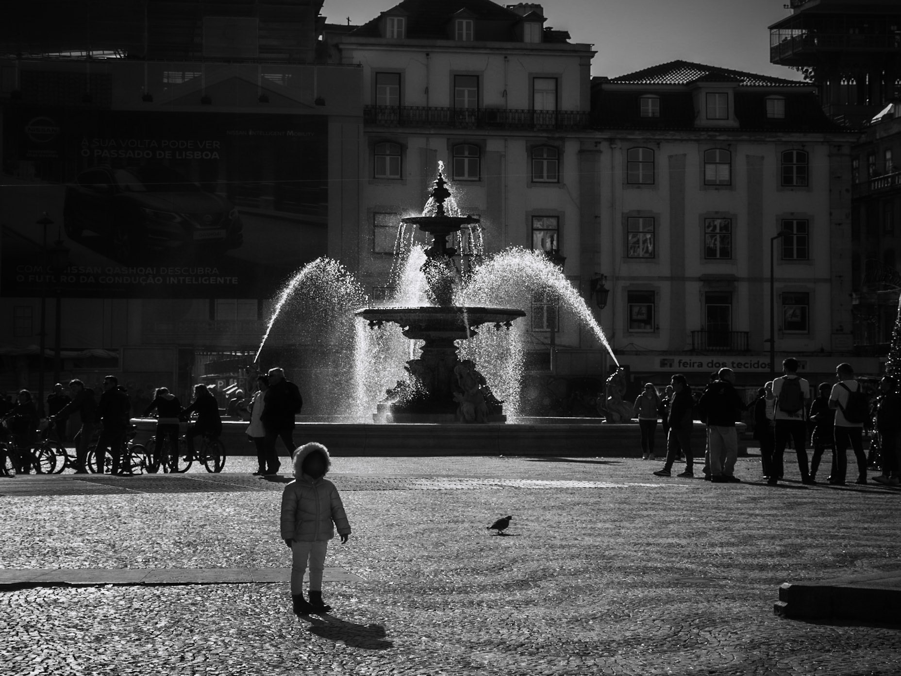 Lisbon, 2018. A little girl poses in Rossio Square for her father.