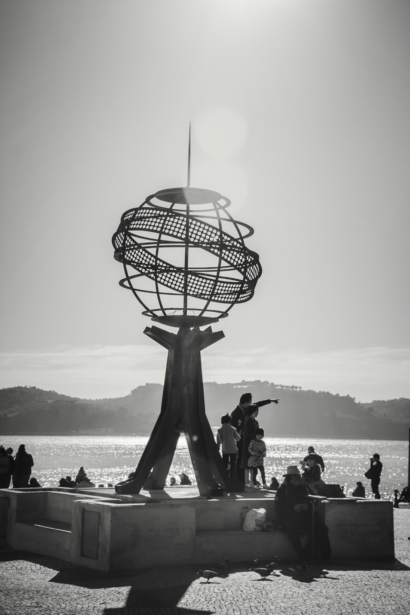 Lisbon, 2018. A man points the horizon to his children at the Monument of Discoveries.