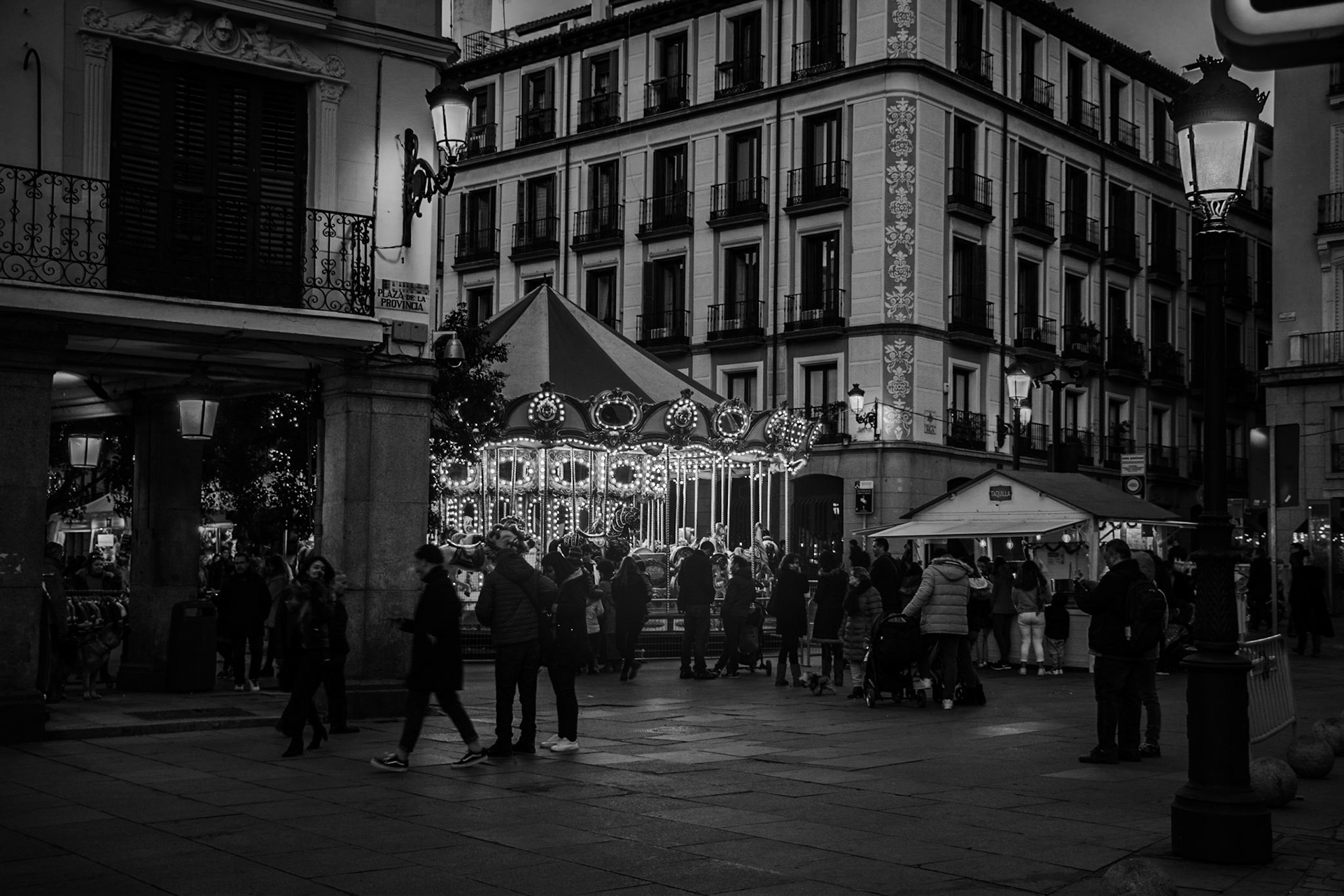 Madrid, 2019. People gather around a merry-go-round installed for the holidays.
