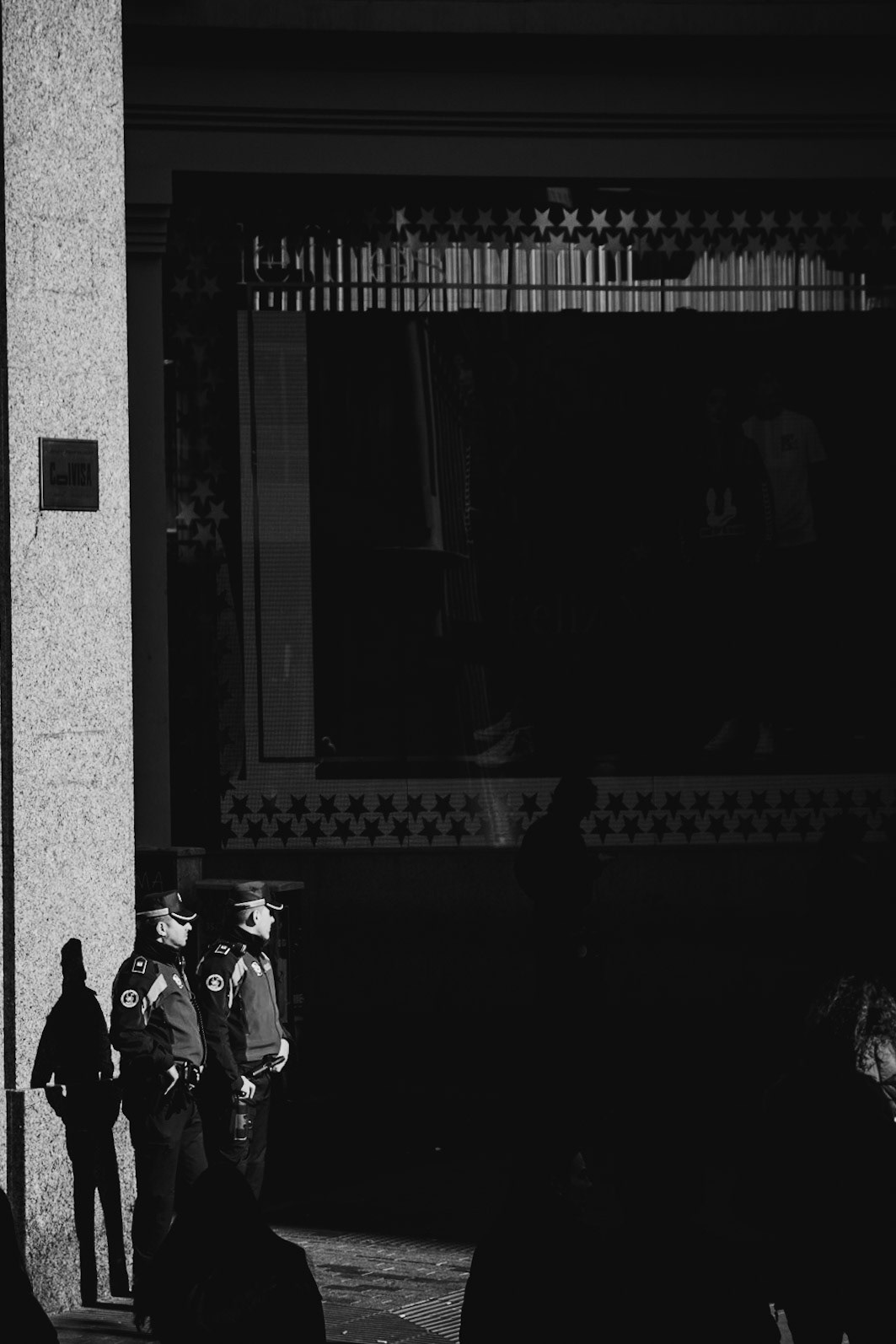 Madrid, 2019. Two police officers observe a commercial district.
