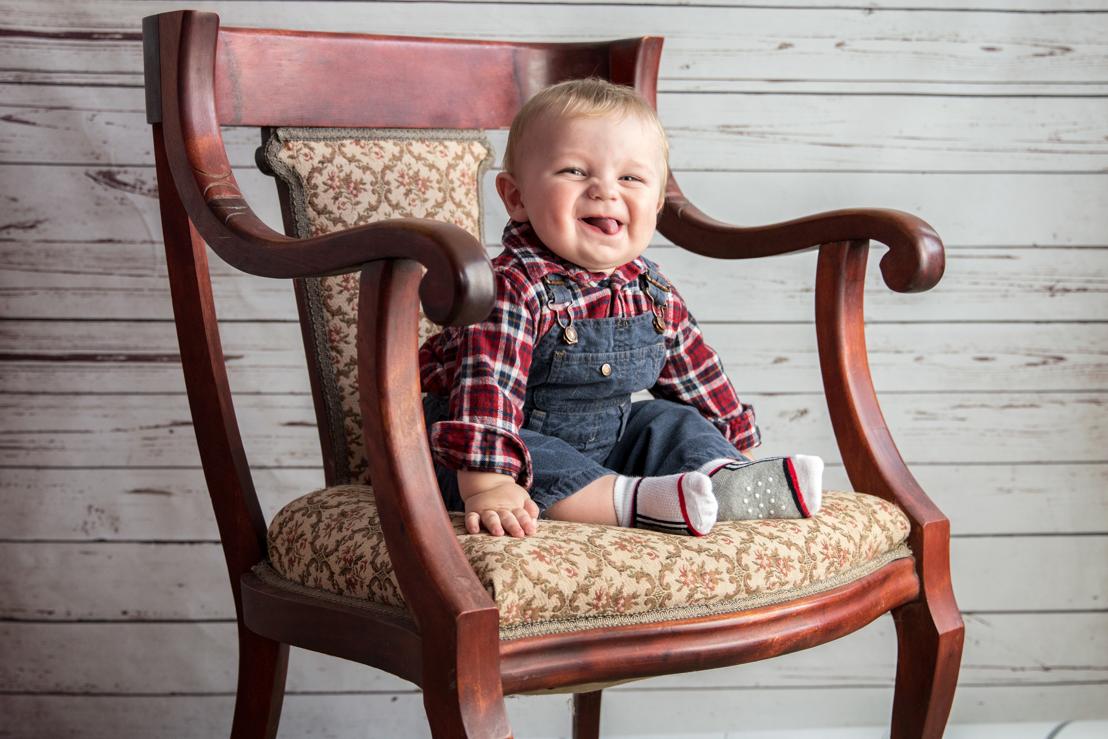 little boy sitting in a big chair laughing