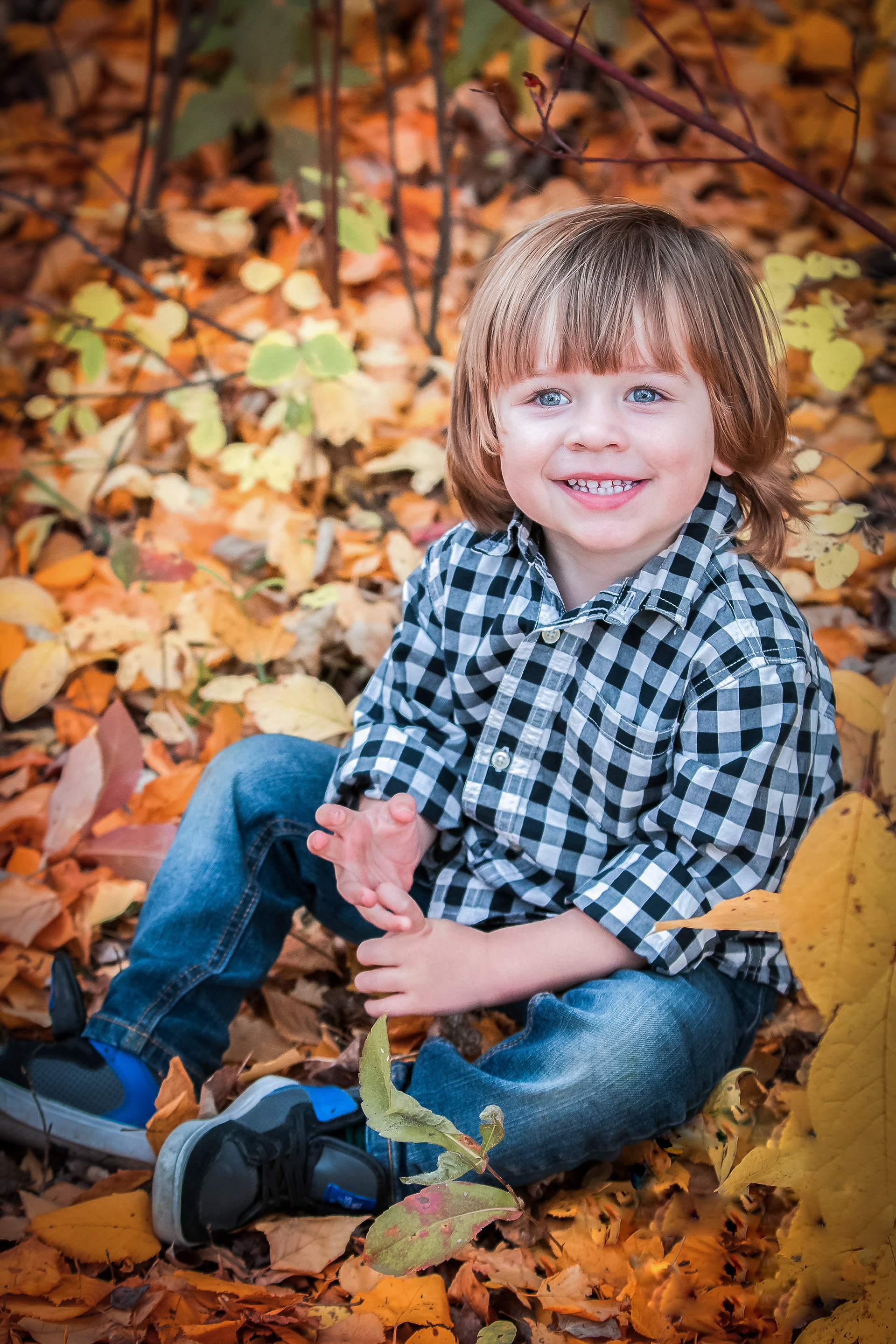 toddler sitting in fall leaves