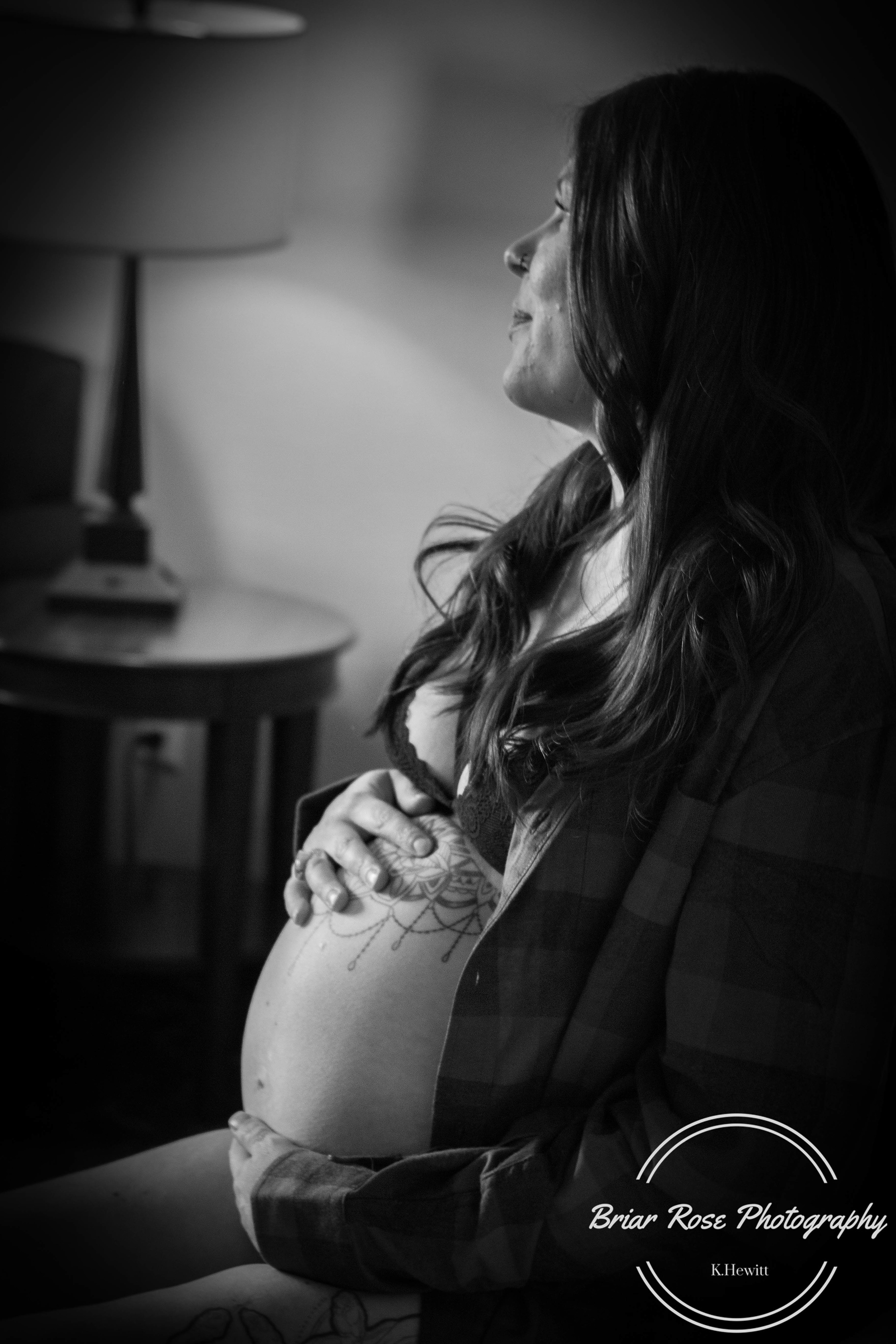mom in black and white holding baby belly