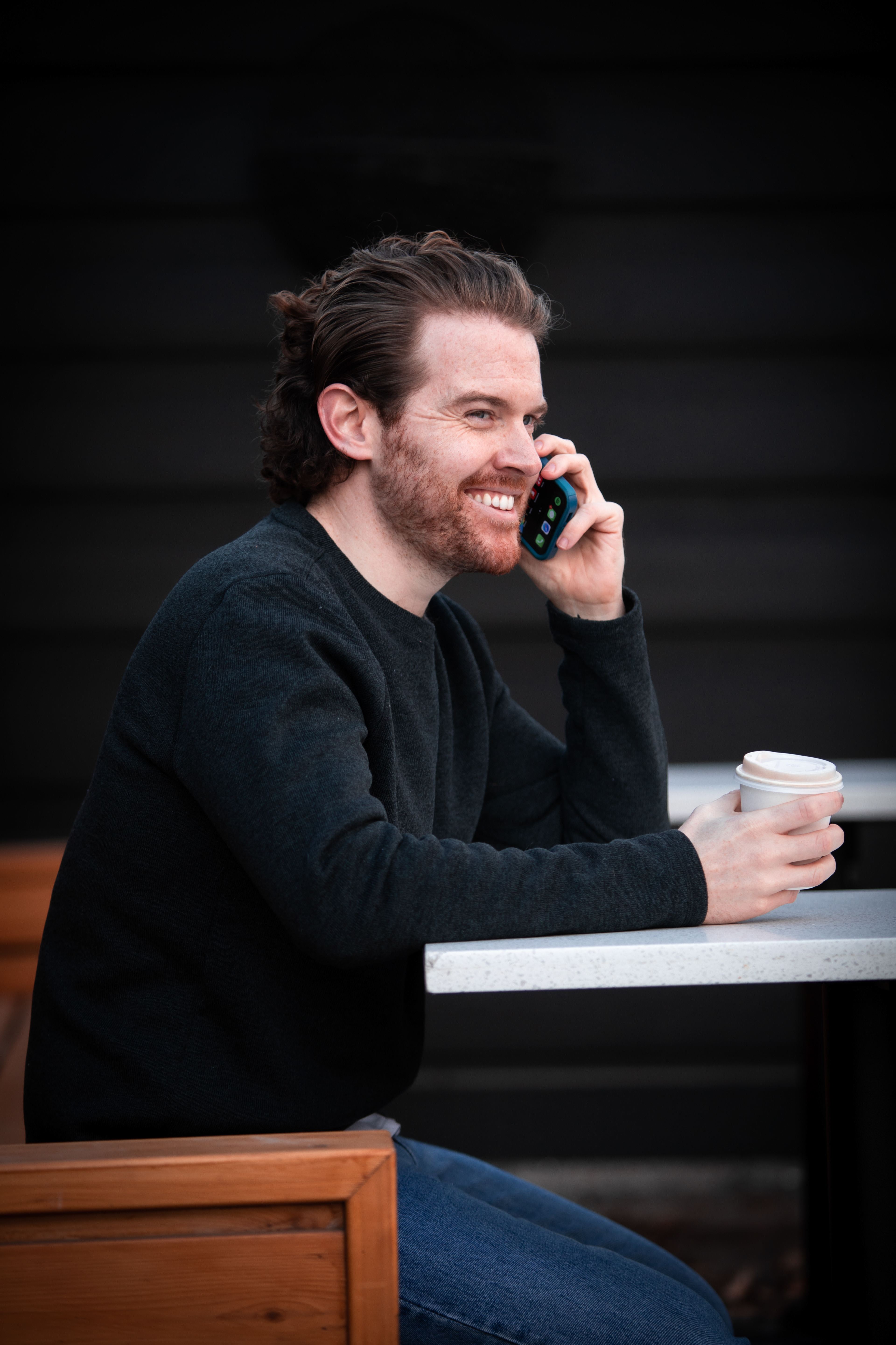 man having coffee talking in the phone