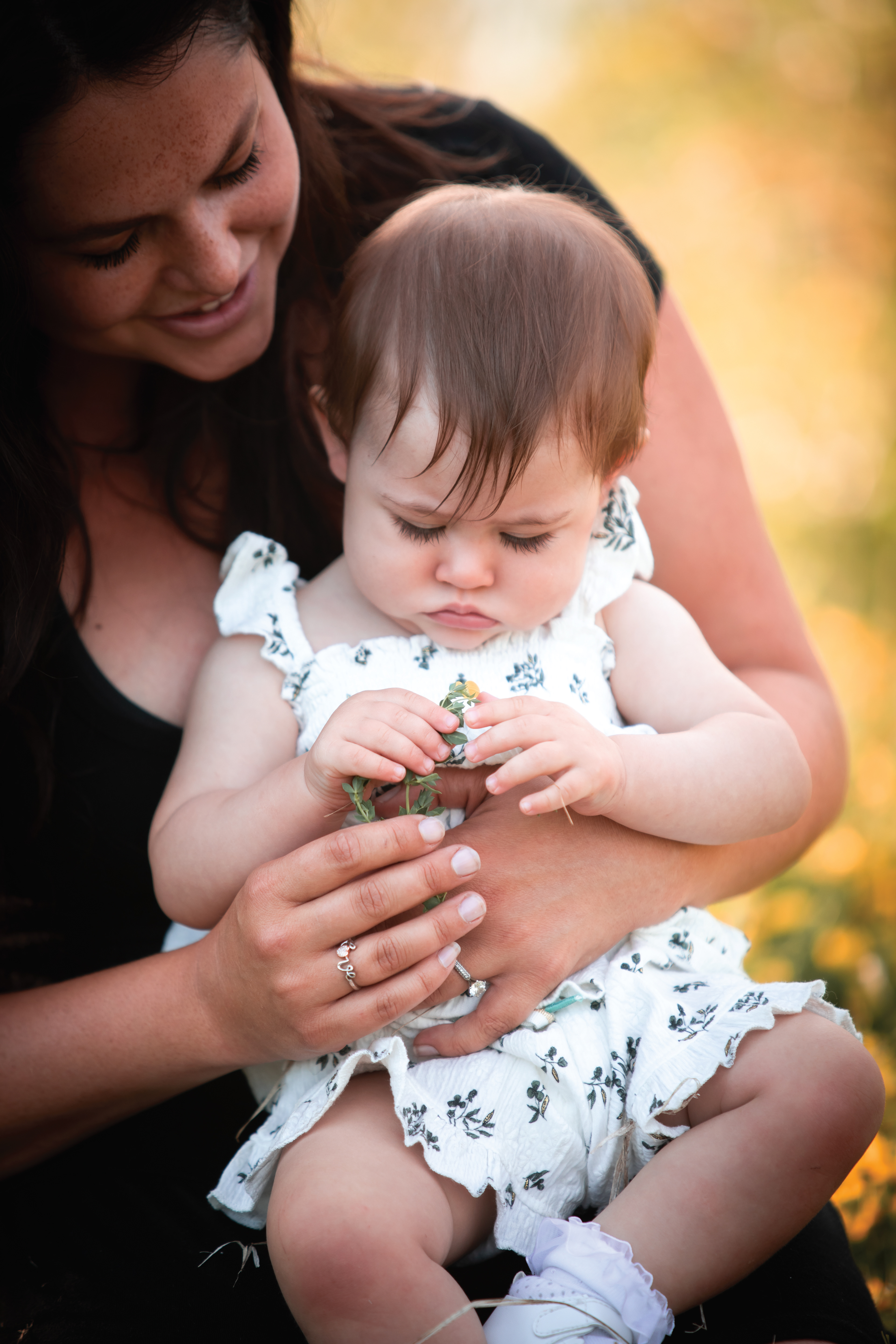 mom and baby holding a flower