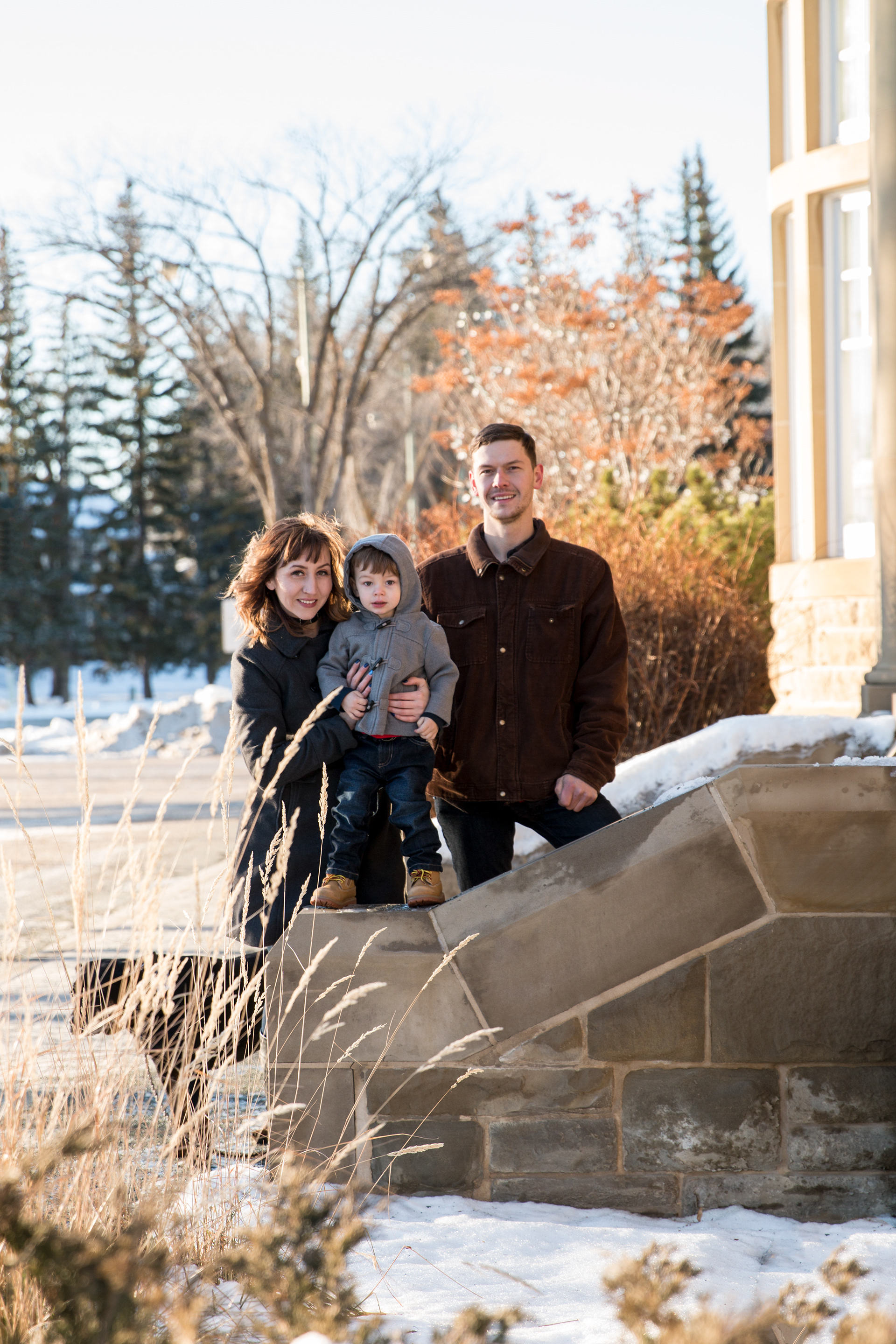 mom, dad and son standing on the stairs