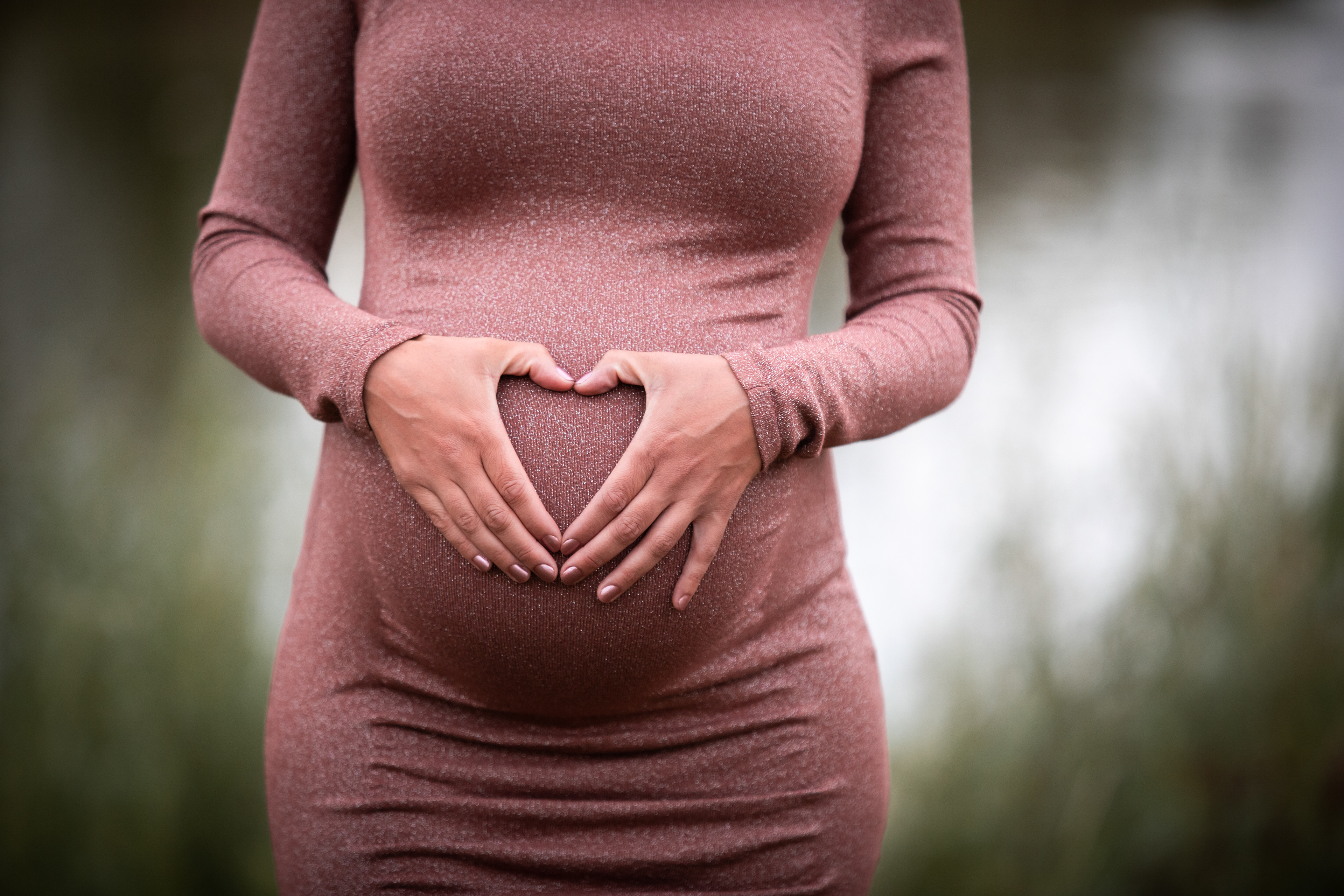 pregnant mom making heart on her belly with hands