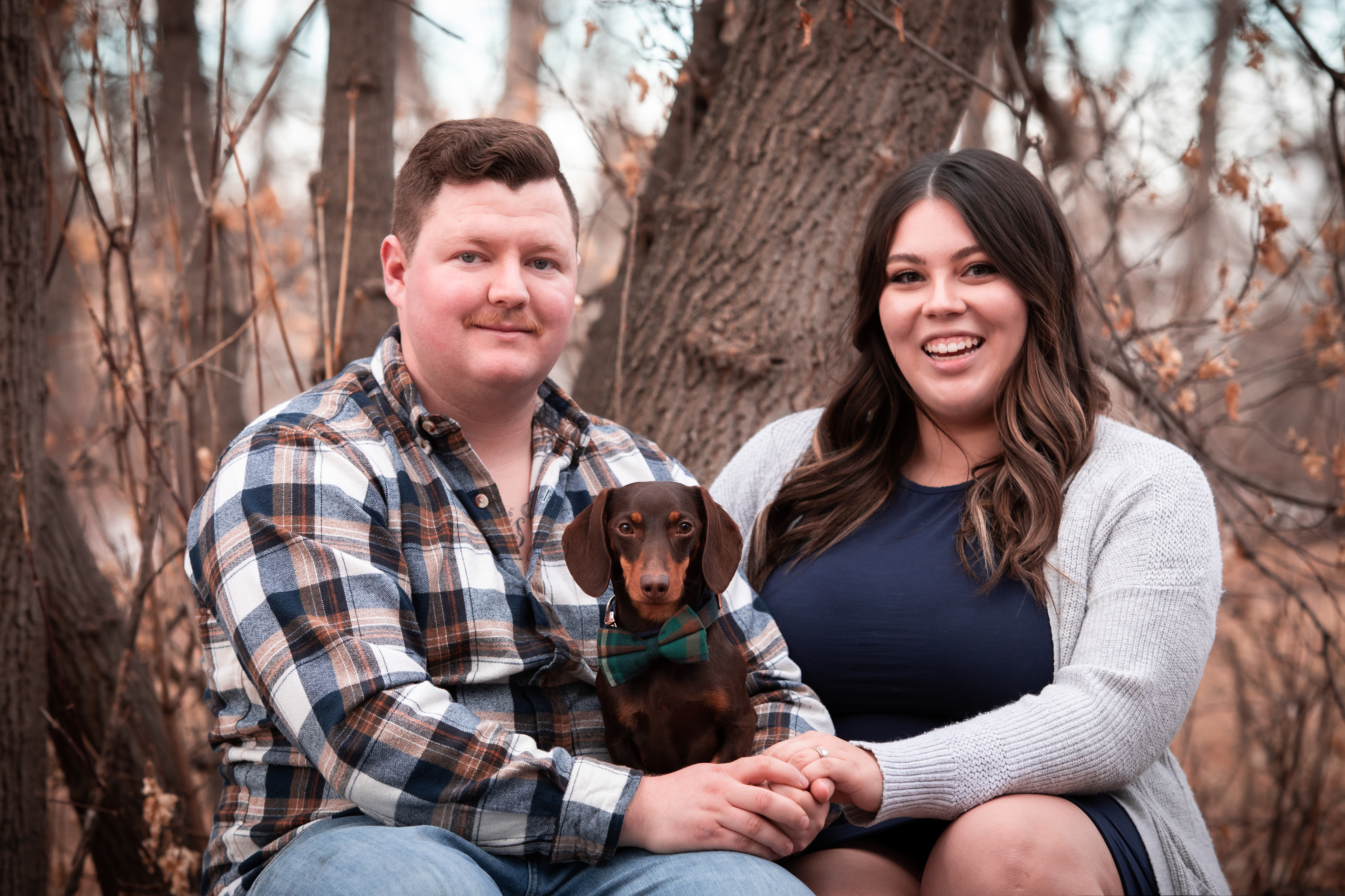 man and woman smiling at camera with dog