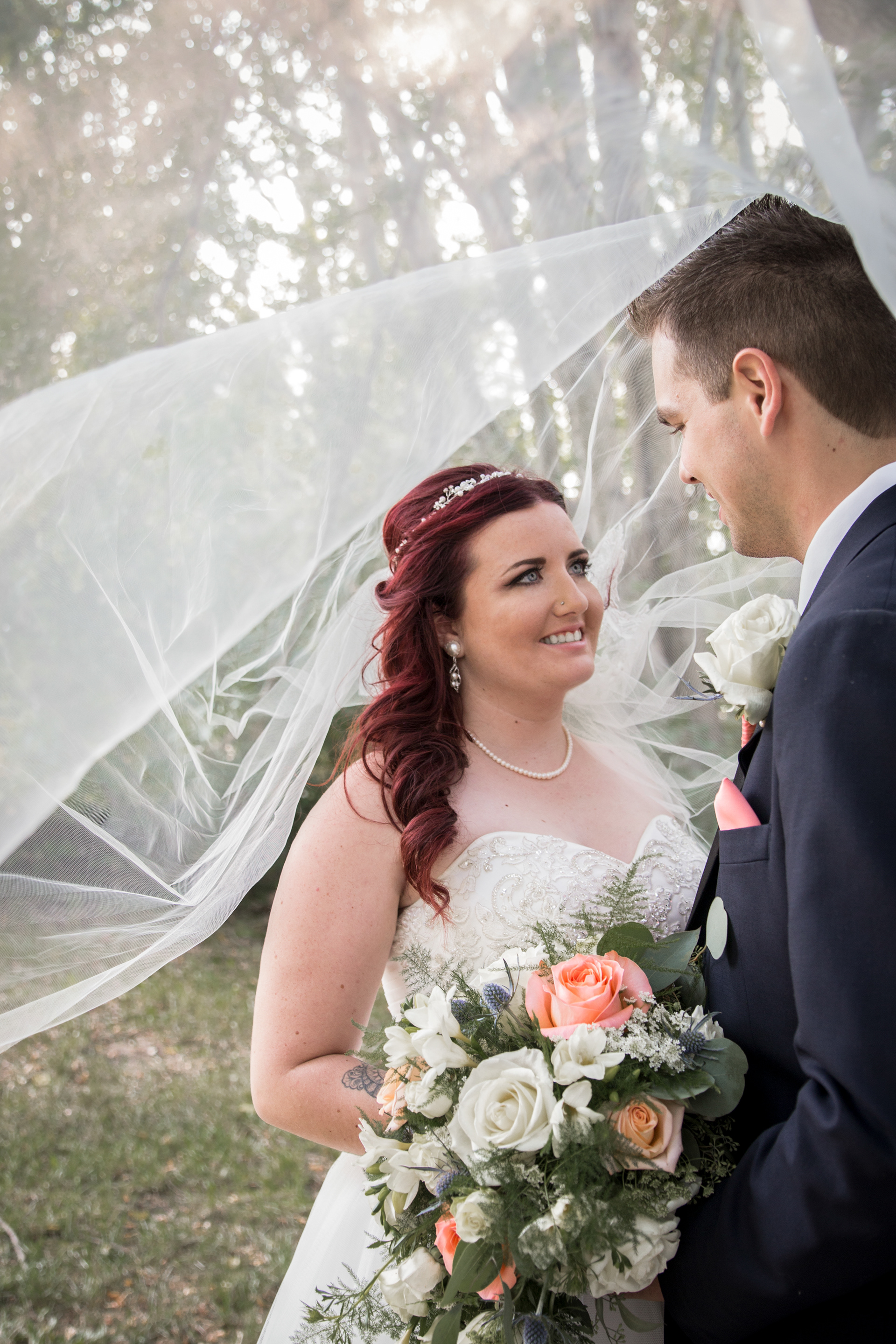 Bride and groom summertime veil over them in Edmonton Alberta