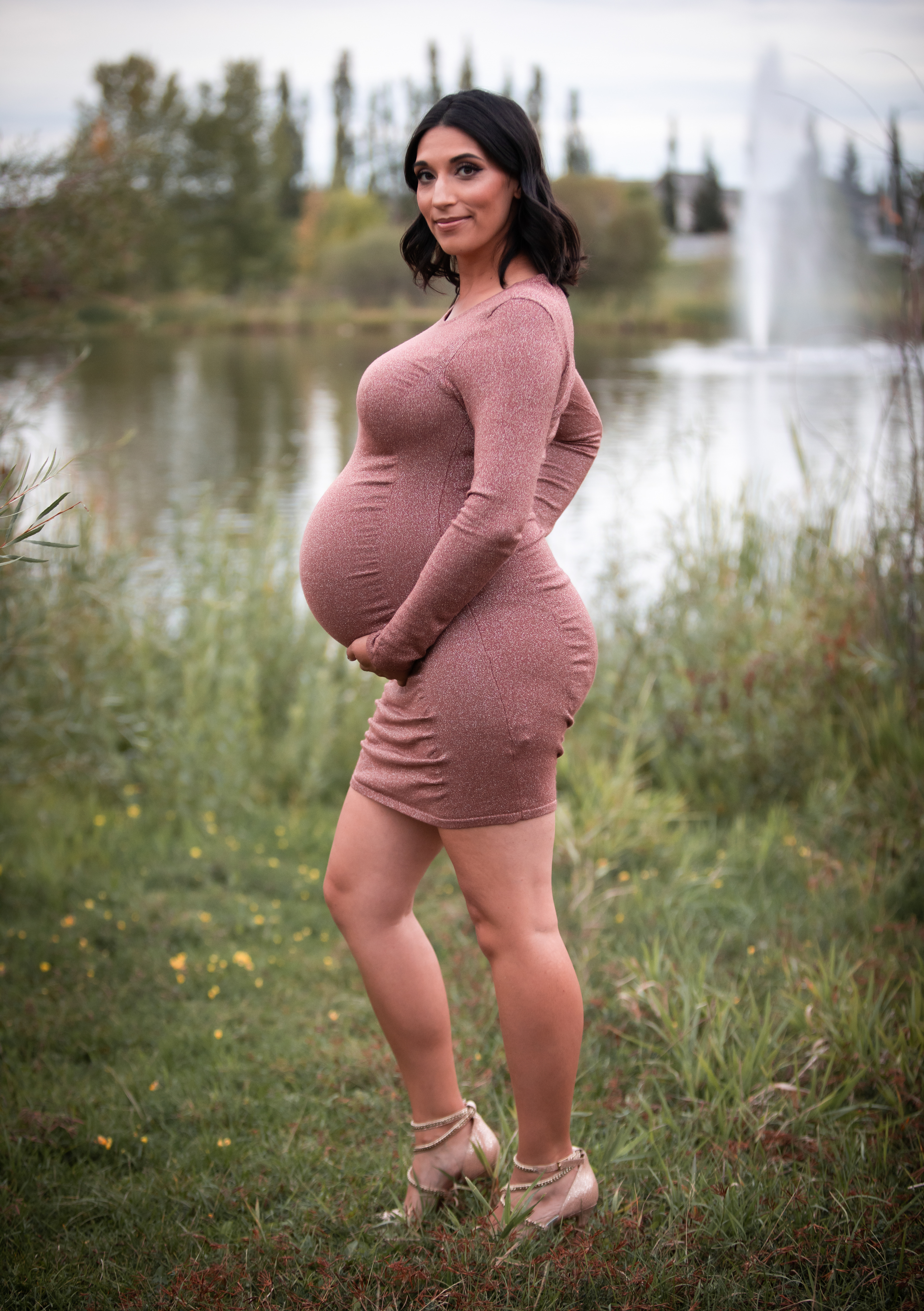 pregnant mom showing off belly by the water