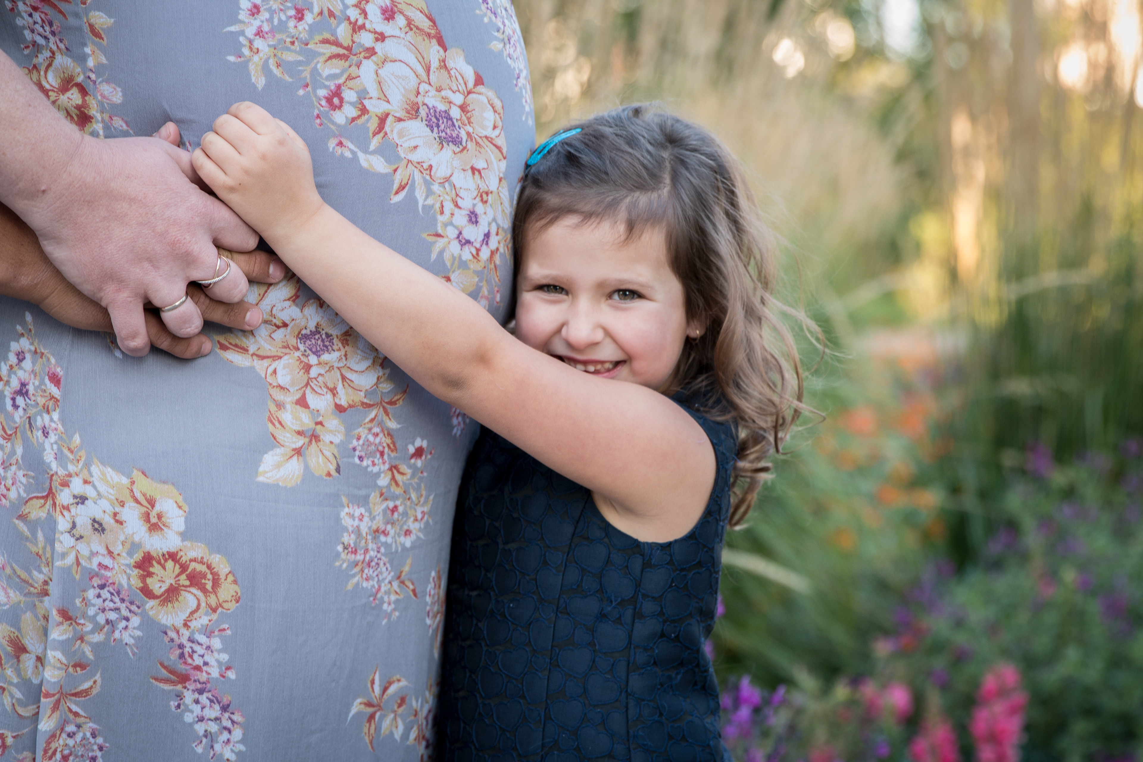 big sister hugging baby belly