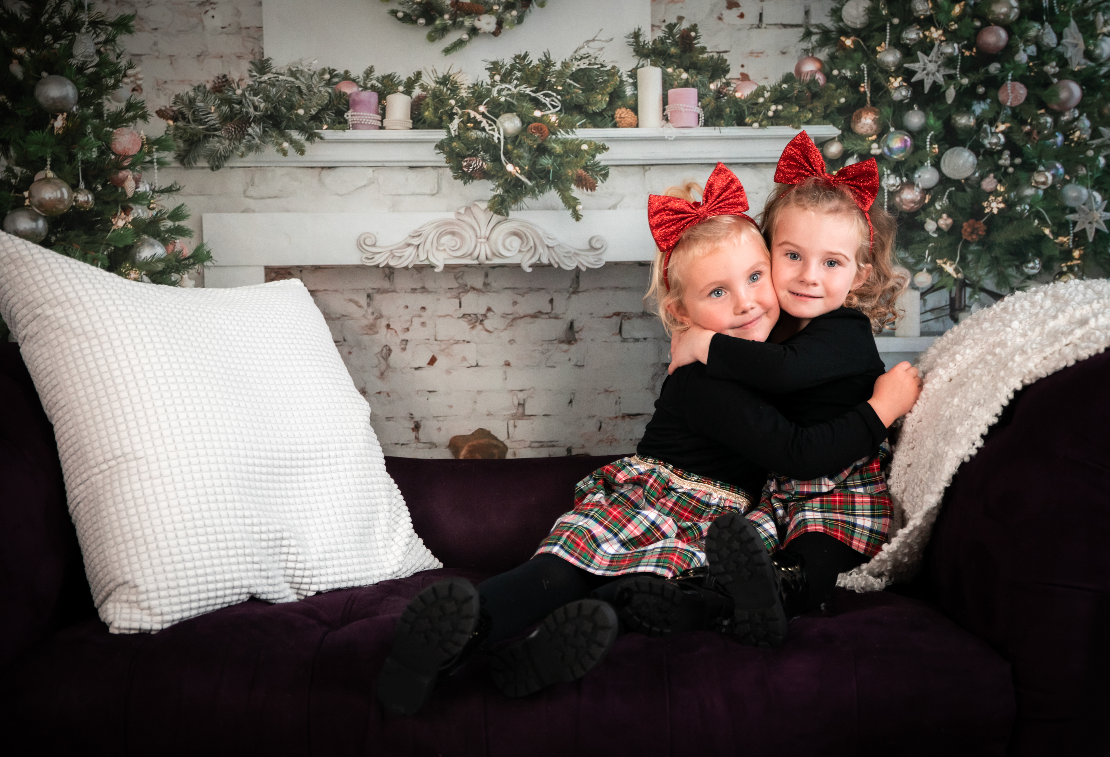 two little girls hugging in matching christmas outfits