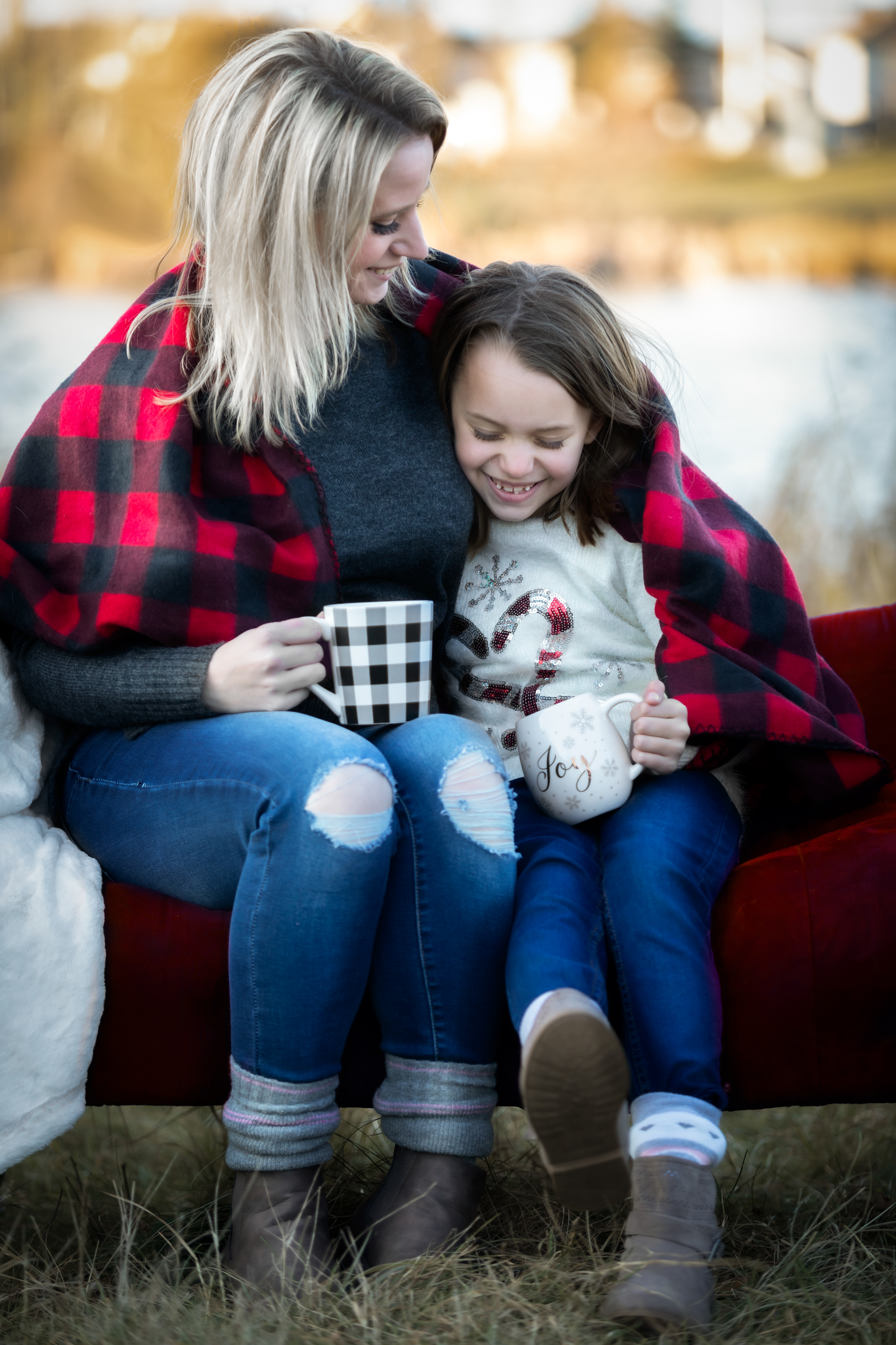 mom and daughter laughing drinking hot coco