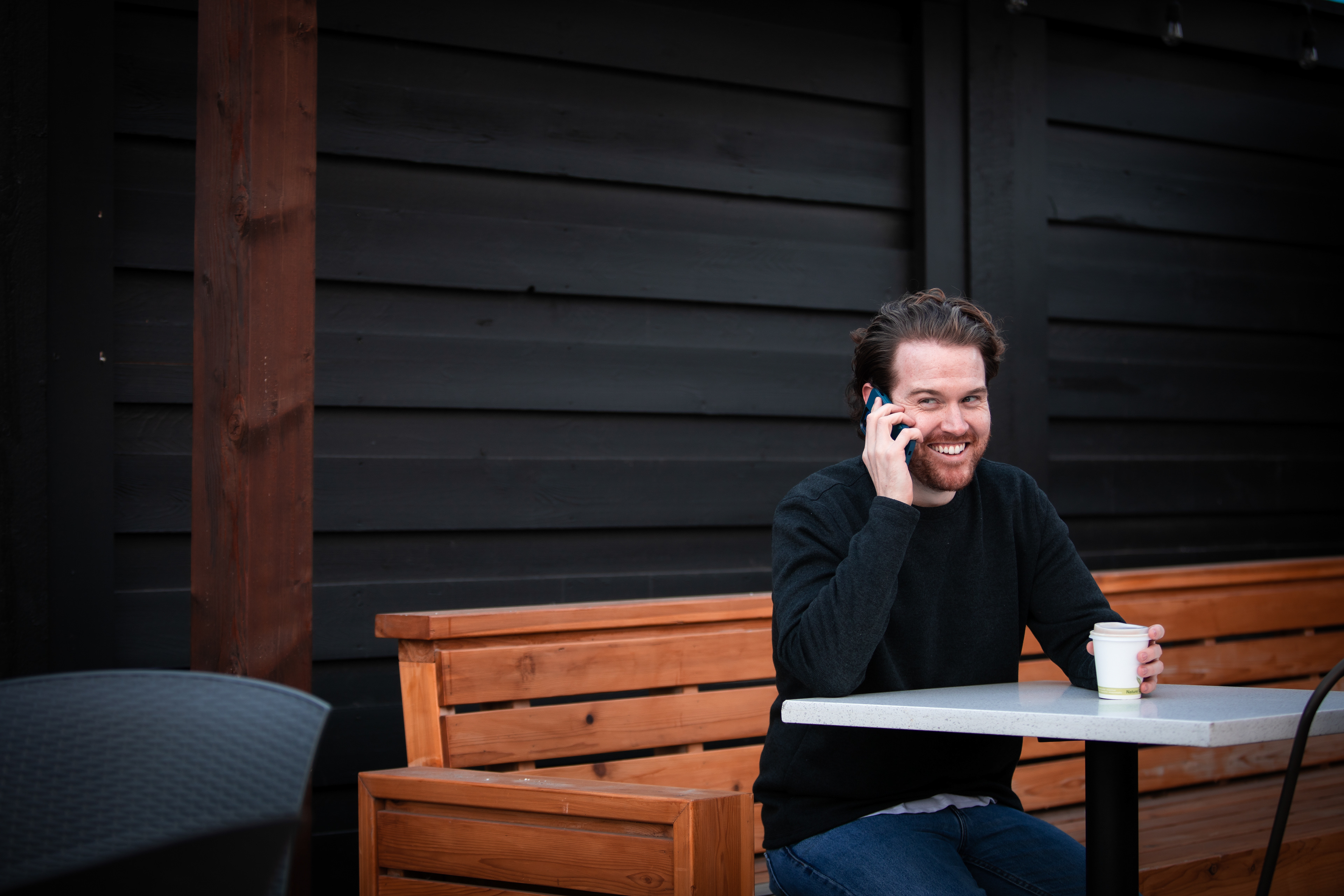 man having coffee talking in the phone