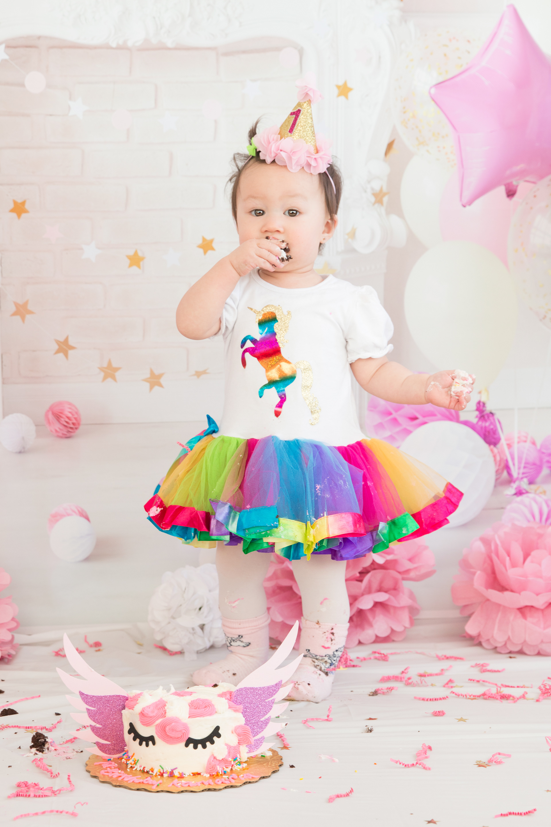 baby standing eating cake 