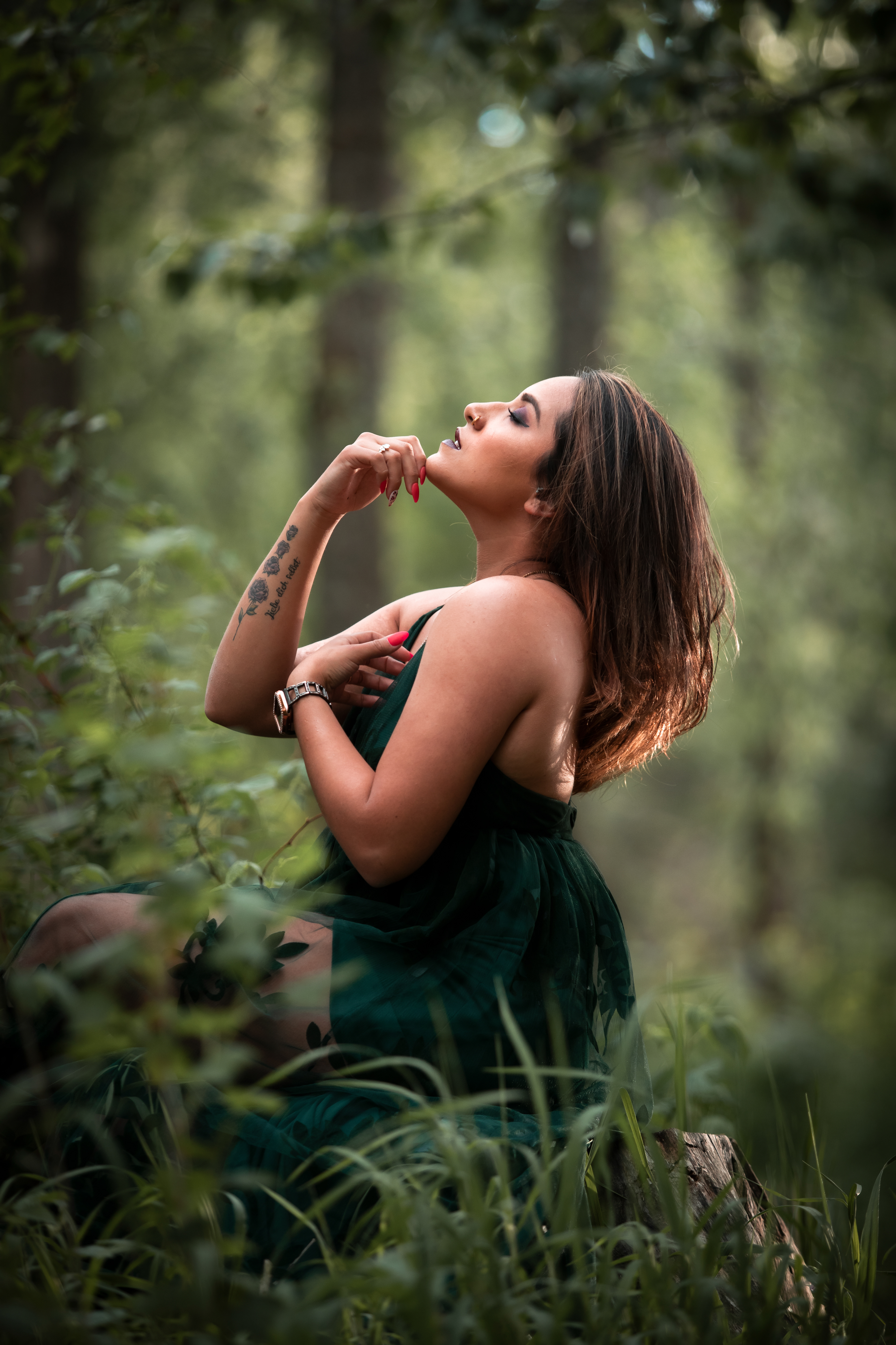 Model leaning back sitting on a three stump