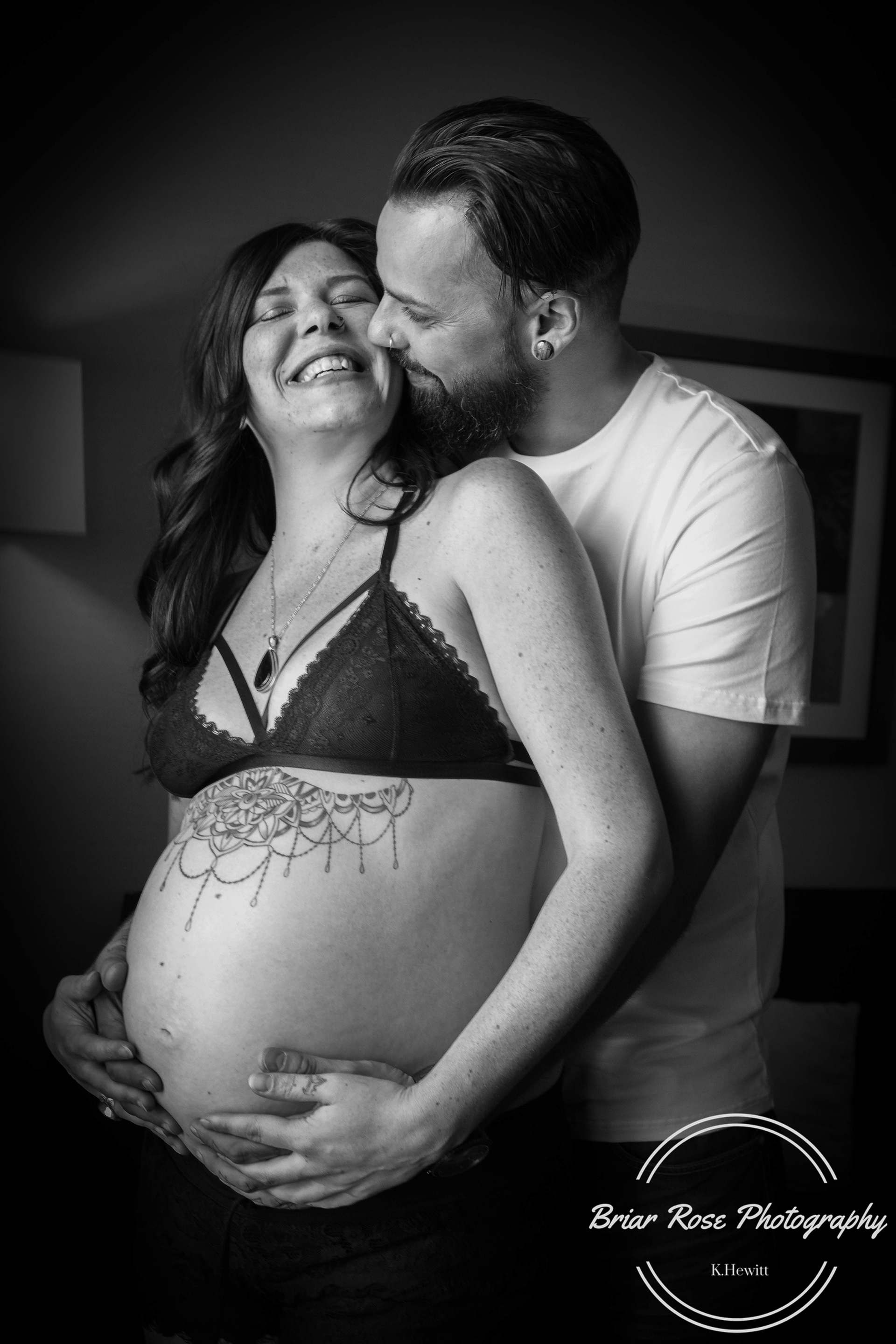 mom and dad with baby belly in black and white