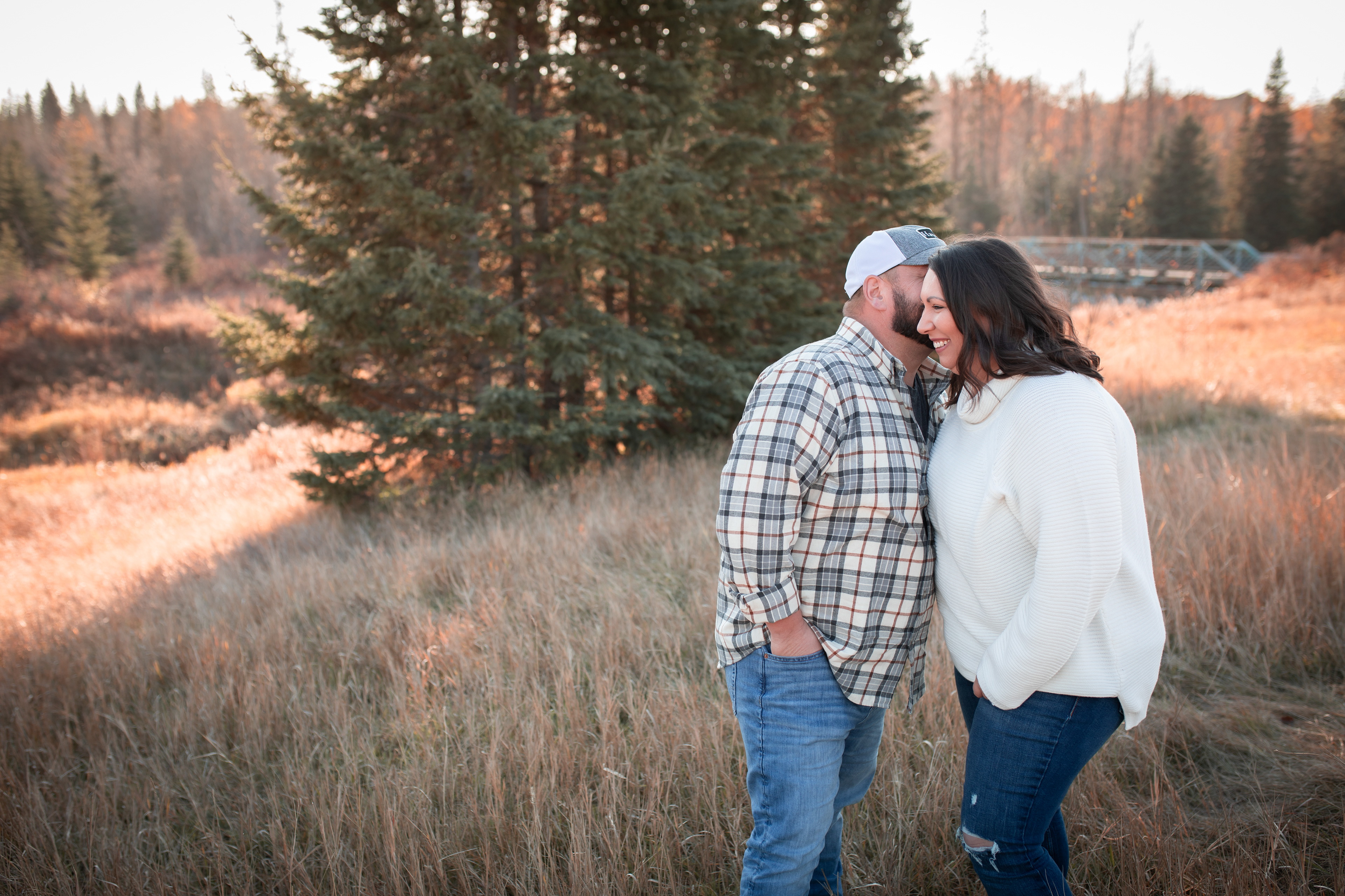 man whispering in woman's ear Edmontons best engagement photographer