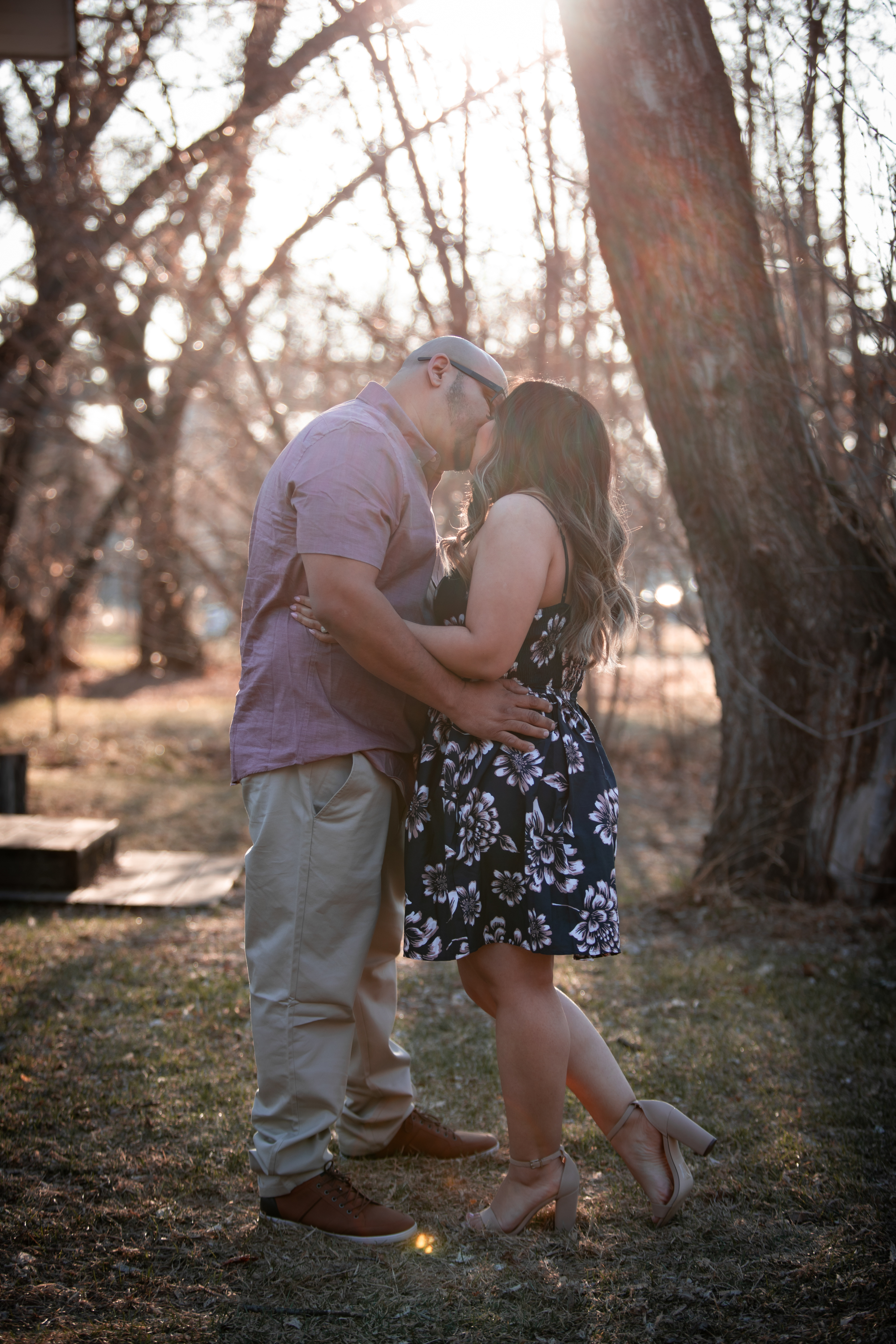 man and woman kissing with her foot popped