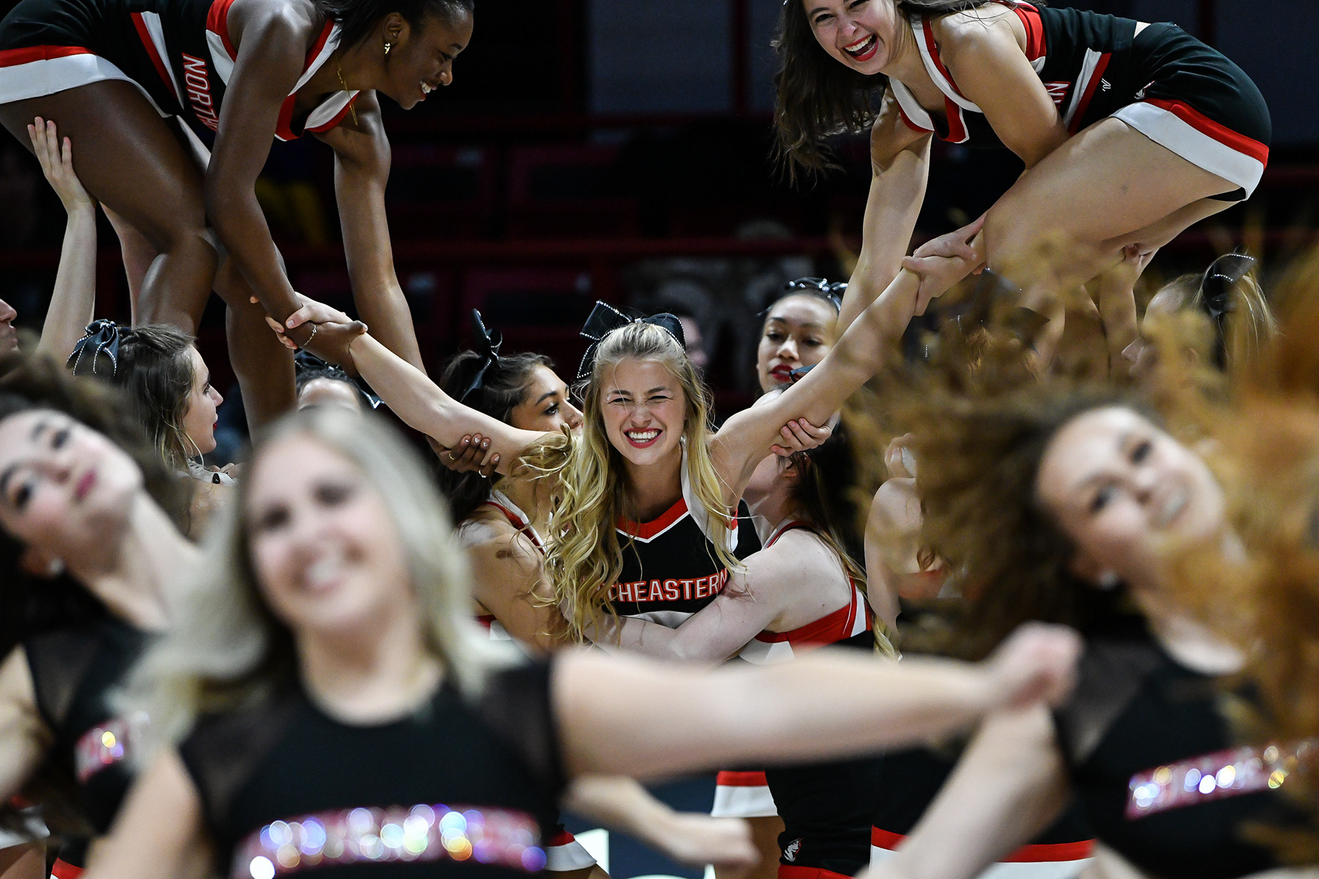 Northeastern Cheer 2022: Kinga Lewandowska performing a cheer stunt during the half time performance with the cheer and dance teams at the Northeastern vs Harvard mens basketball home opener