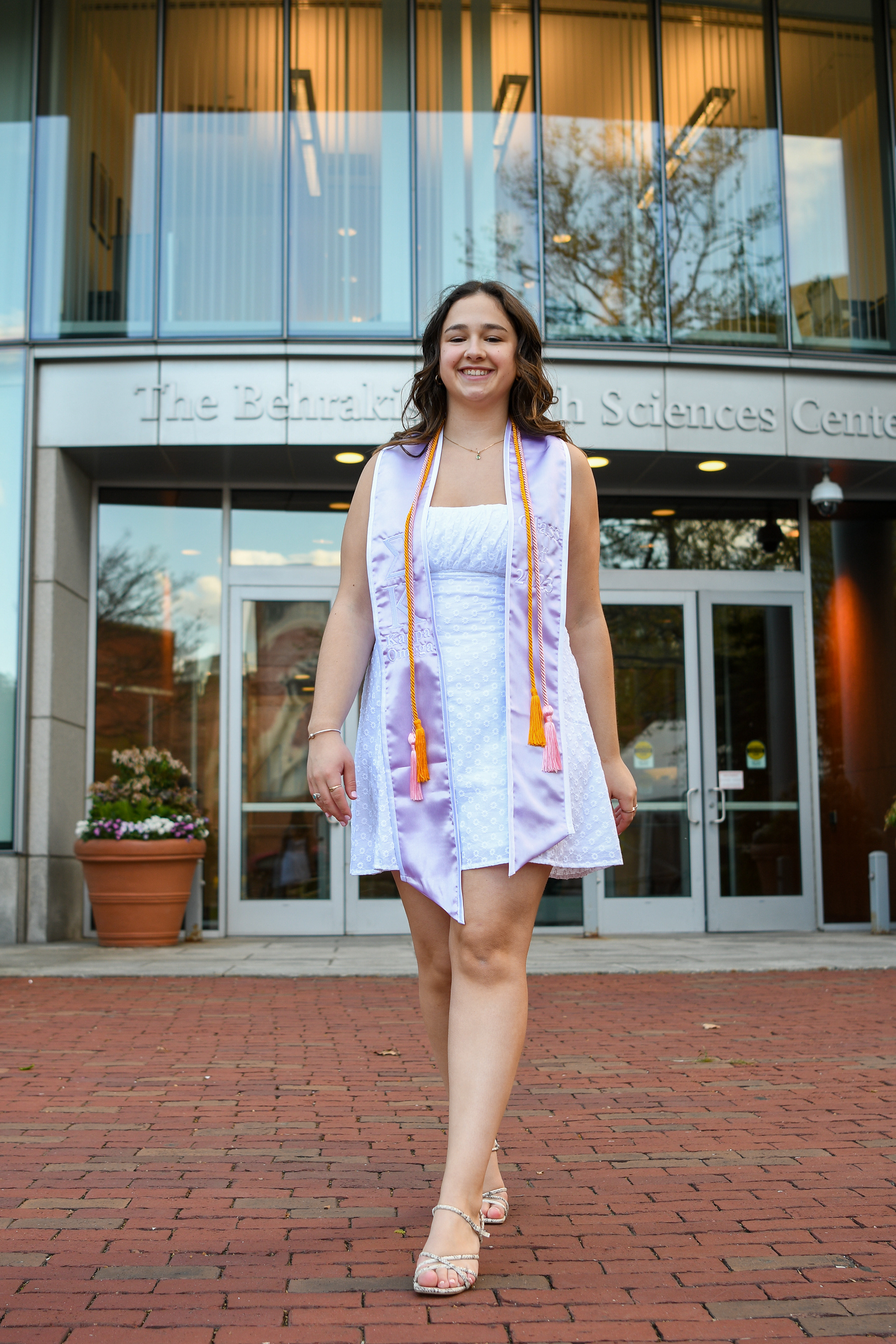 Fiona Traub walking away from the Health Sciences building as she looks forward to starting her next chapter at PT school at USC